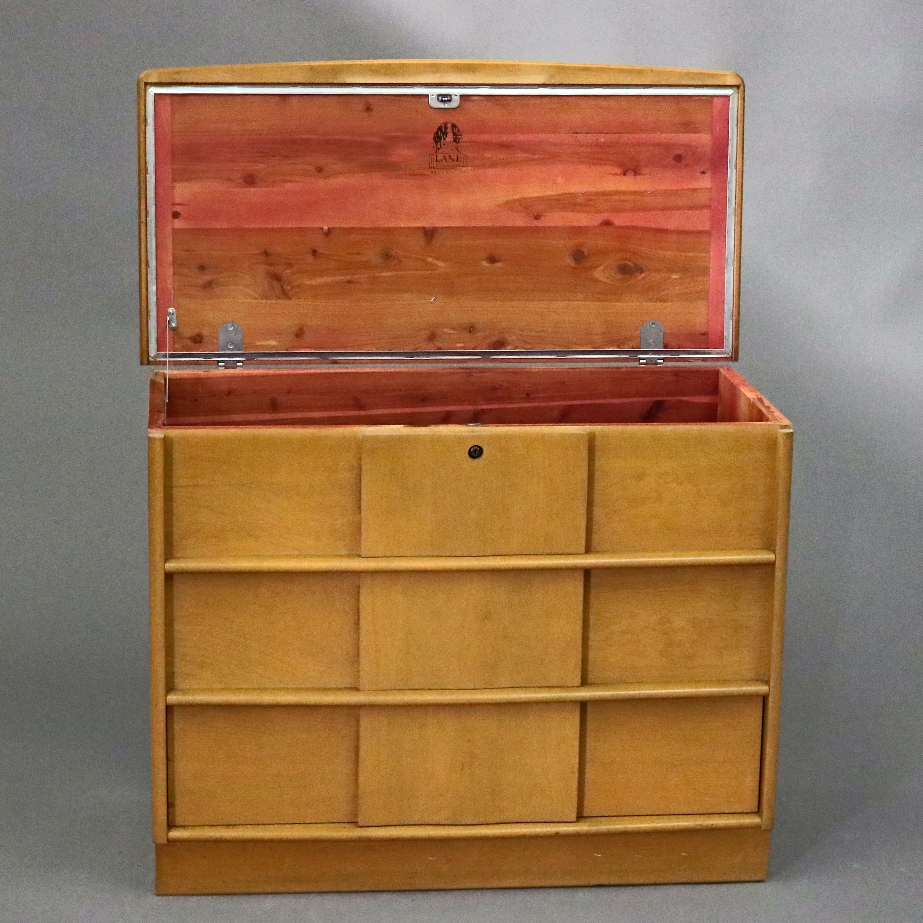 A Mid-Century Modern Heywood Wakefield style mule blanket chest by Lane Furniture offers blonde exterior finish with lift top opening to reveal cedar lined chest having two faux drawers over one long drawer, Style 6684-31, maker mark branded on lid