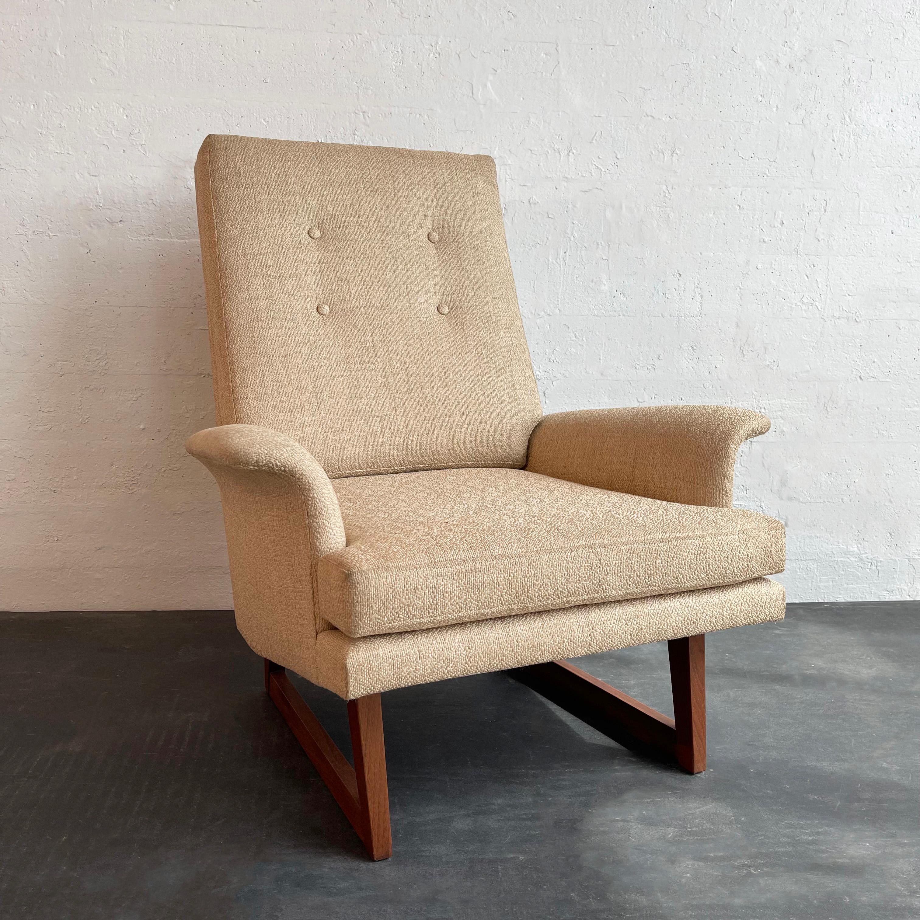 Mid-century modern, high-back, lounge chair attributed to Milo Baughman offers comfort in high style. This enveloping chair features sculptural, walnut, sleigh legs and a fully upholstered body in flax linen blend with wide rolled armrests. 