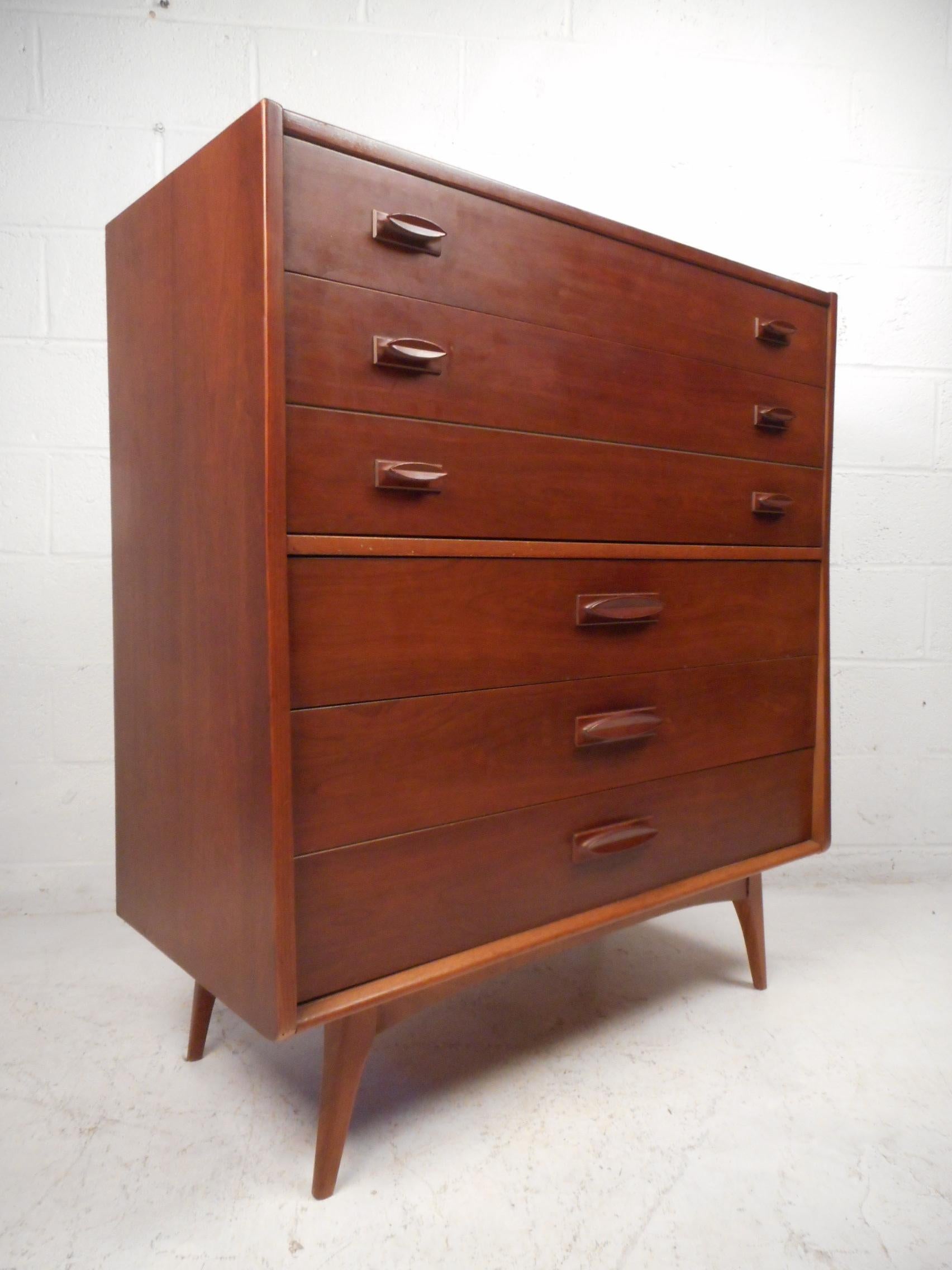 Beautiful midcentury highboy dresser made by United Furniture Corporation. Five dovetail joined drawers with one oversized partitioned drawer provide ample room for storage. Sculpted drawer pulls and understatedly stylish splayed legs give this case