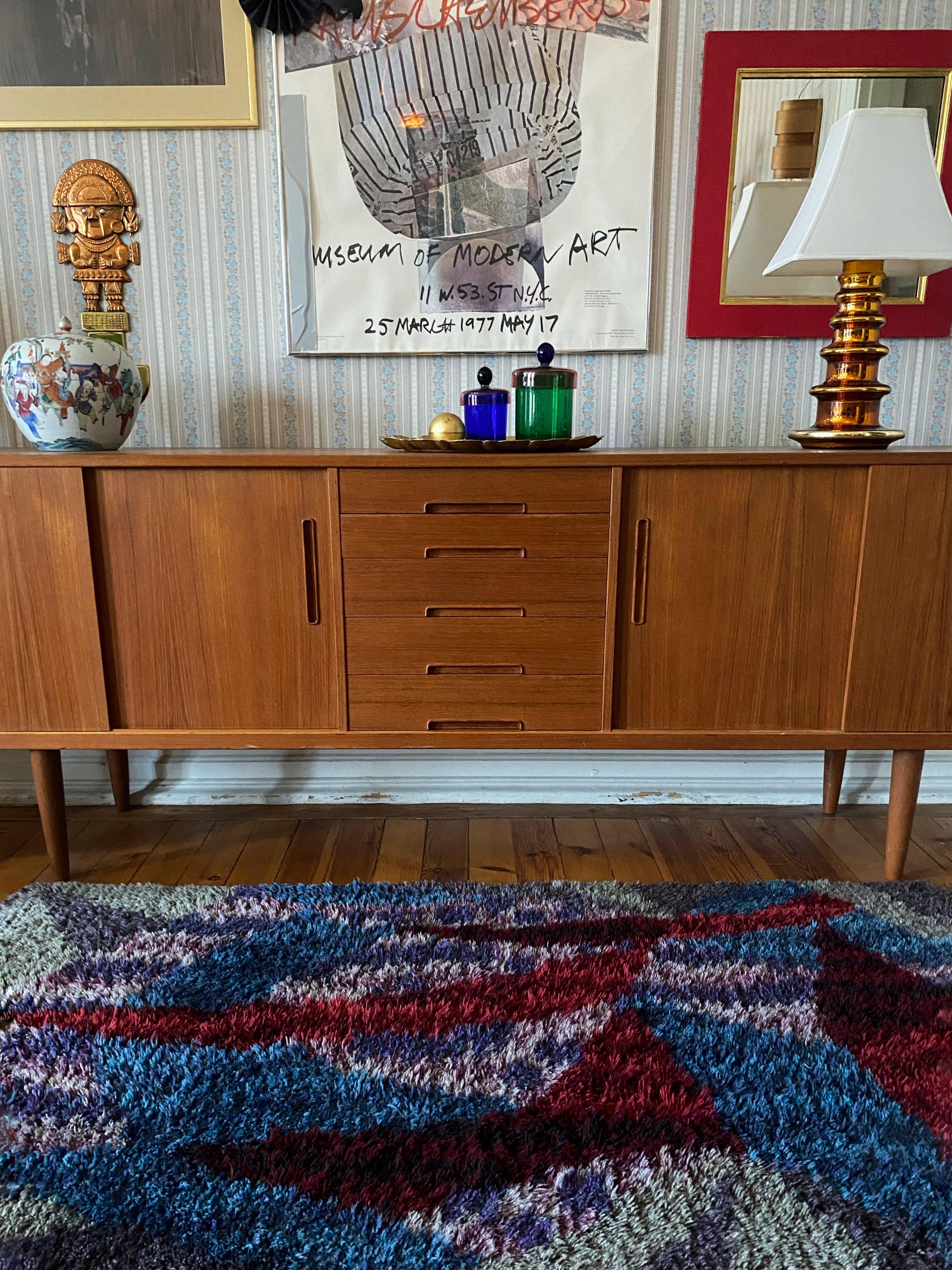 This exquisite mid-century scandinavian modern rya rug, handmade in Sweden during the 1960s, is a true piece of art. Crafted from premium wool with a soft, lustrous pile, it features a rich color palette of turquoise, indigo, blue, burgundy, and