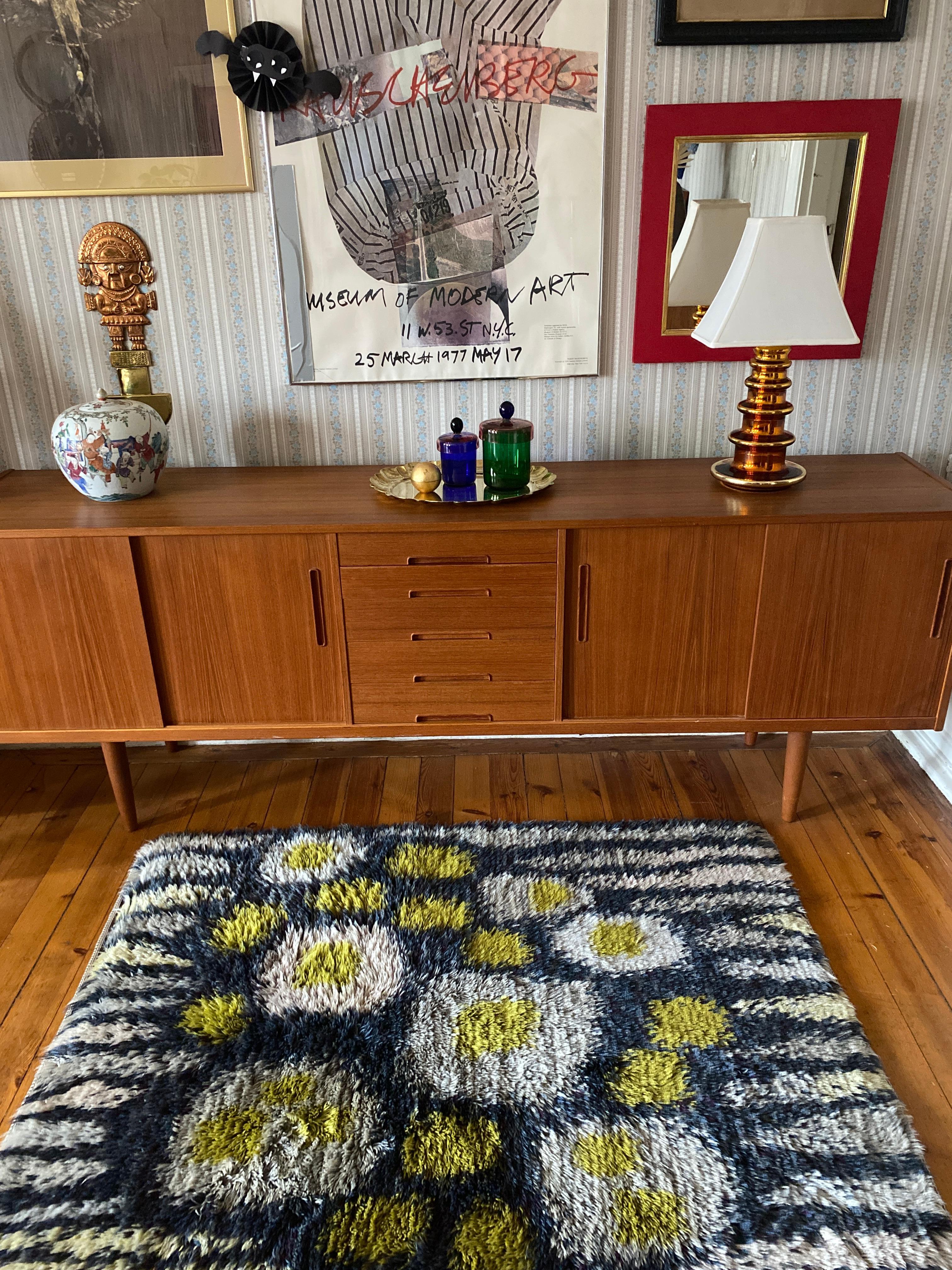 This exquisite mid-century Scandinavian Modern rya rug, handmade in Sweden in the 1960s, is a true work of art. Crafted from premium wool with a soft, lustrous pile, it showcases a rich color palette of blue, yellow, grey, and off-white.

The