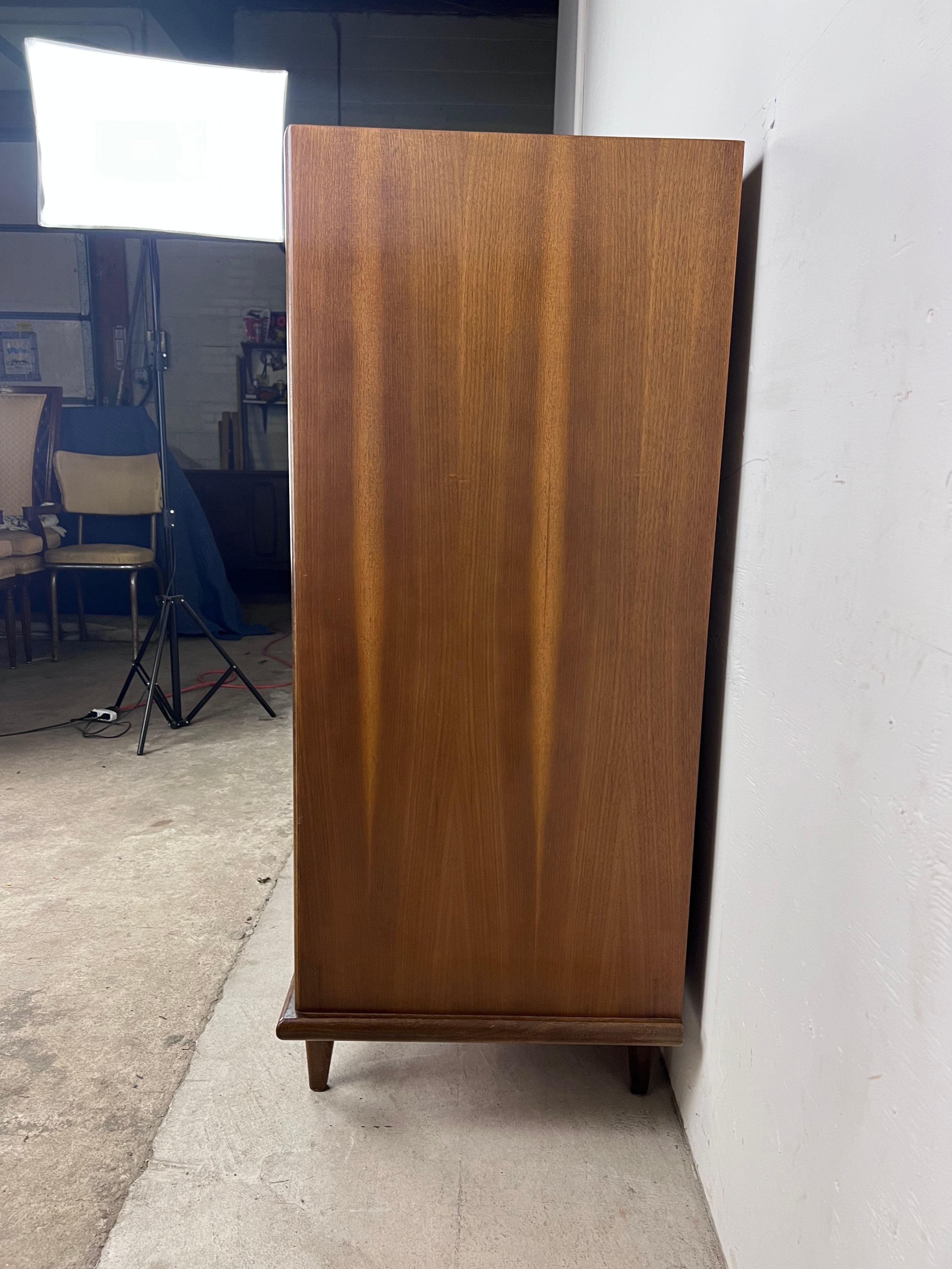 This Mid-Century Modern highboy dresser by American of Martinsville features hardwood construction, original walnut finish, five dovetailed drawers with unique beveled drawer fronts, atop tapered legs.??



Dimensions: 40 W 18.5 D 46.5 H. 

