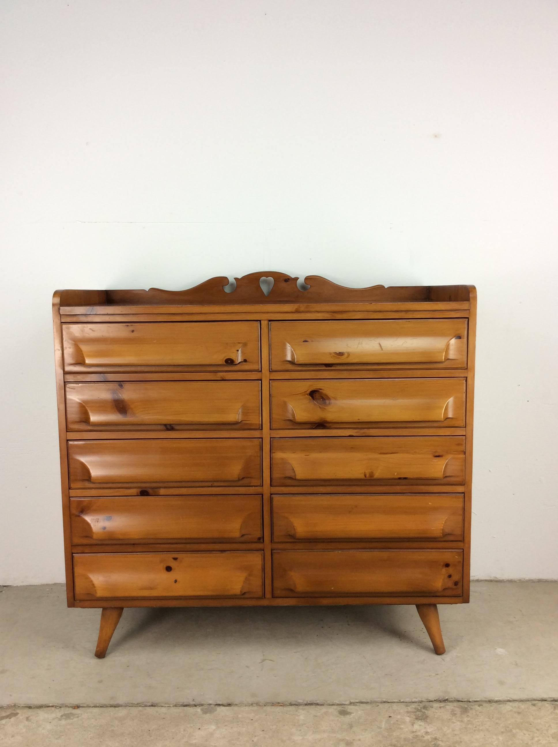 This mid century modern highboy dresser by Franklin Shockey features hardwood construction, original knotty pine finish, ten dovetailed drawers, sculpted drawer pulls, unique hard shaped carving on the back edge, and tapered legs.

Dimensions: