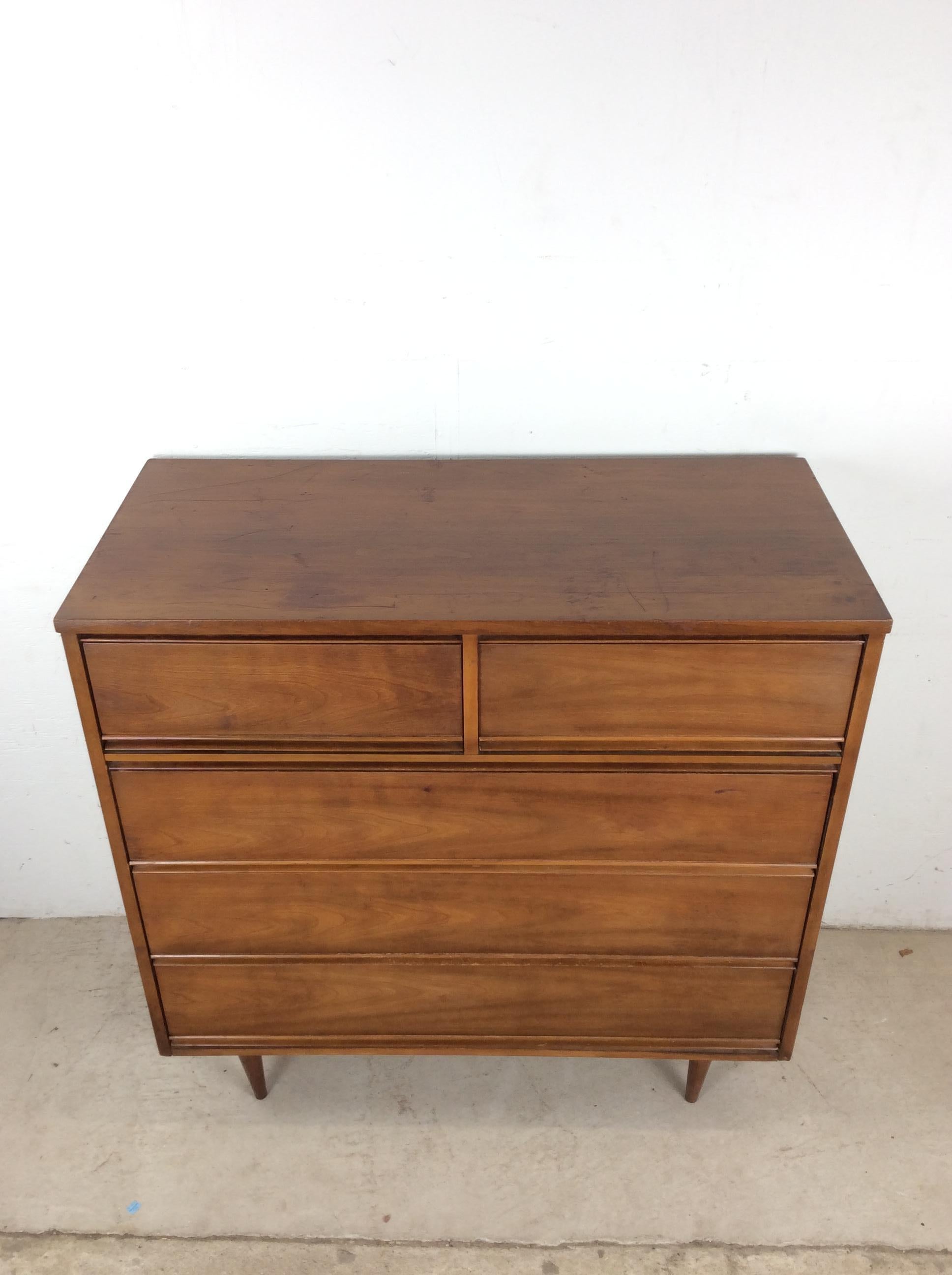 Questo comò Highboy di Harmony House, moderno e di metà secolo, presenta una struttura in legno massiccio, impiallacciatura in noce con finitura originale, cinque cassetti a coda di rondine e alte gambe affusolate. u2028u2028Il comò basso abbinato è