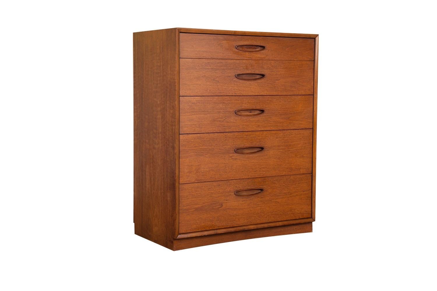 A beautiful, mid-century modern walnut, Heritage Henredon, Highboy Dresser circa early 1960’s. This absolute jewel remains in nearly pristine condition. The lines are clean and elegant. Features five spacious drawers in graduated depths from top to