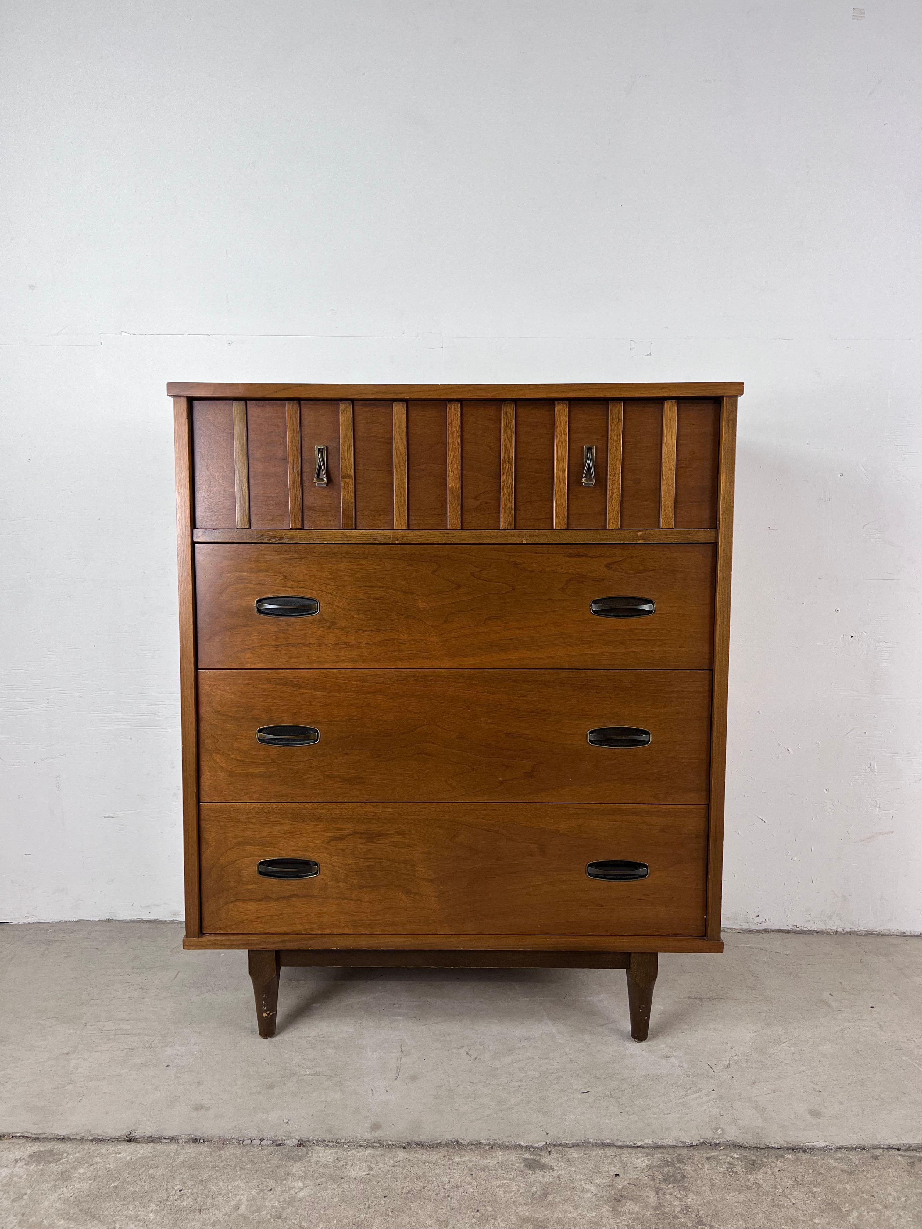 This Mid-Century Modern highboy dresser by Krug features hardwood construction, walnut veneer with original finish, four dovetailed drawers with brass hardware, and tapered legs.??

Dimensions: 34 W 18 D 41.75 H.

