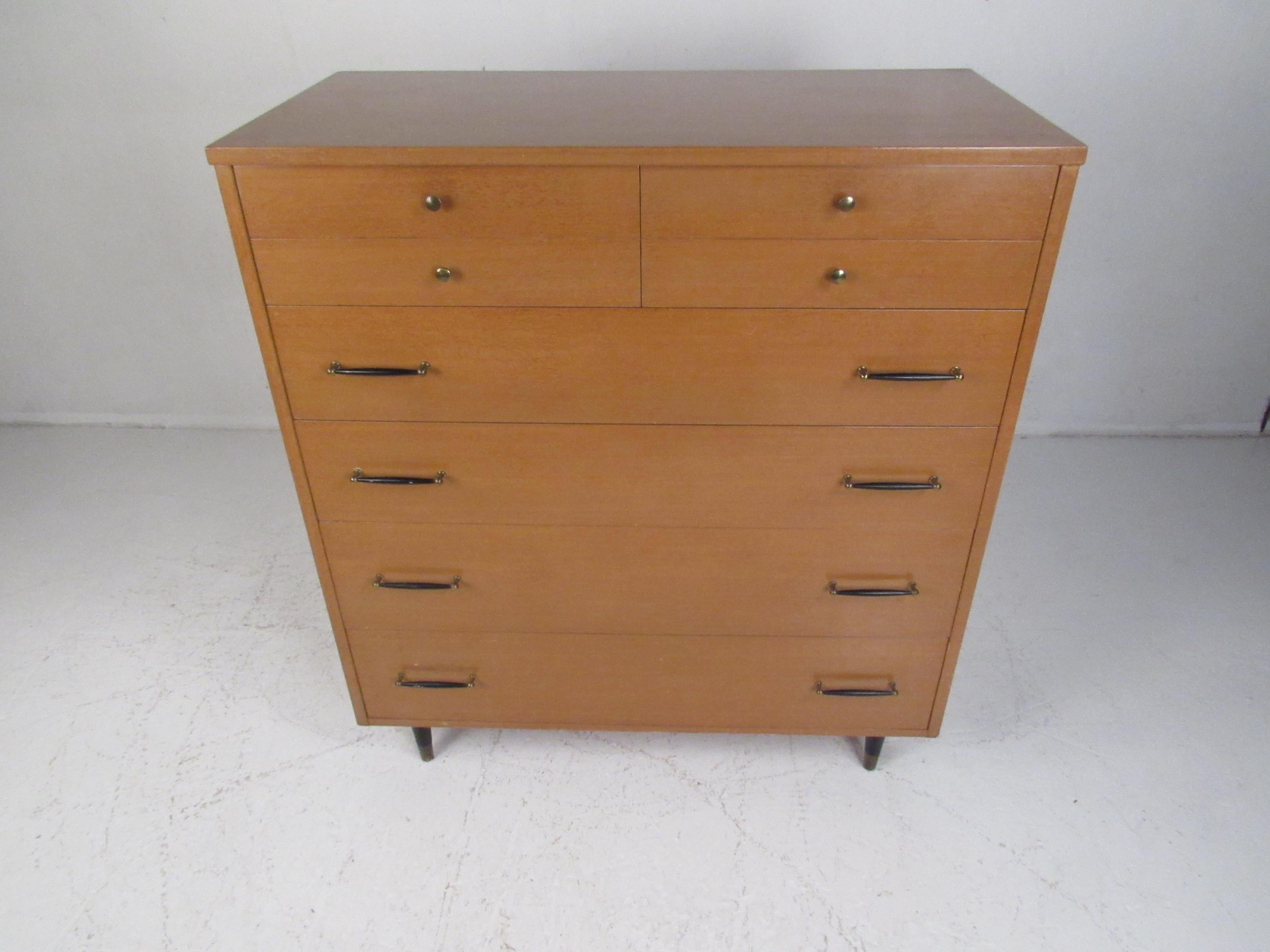 This stunning vintage modern dresser features six hefty drawers providing ample room for storage. A stylish design with various different drawer pulls. This beautiful case piece boasts tapered legs with brass capped feet and an elegant light colored