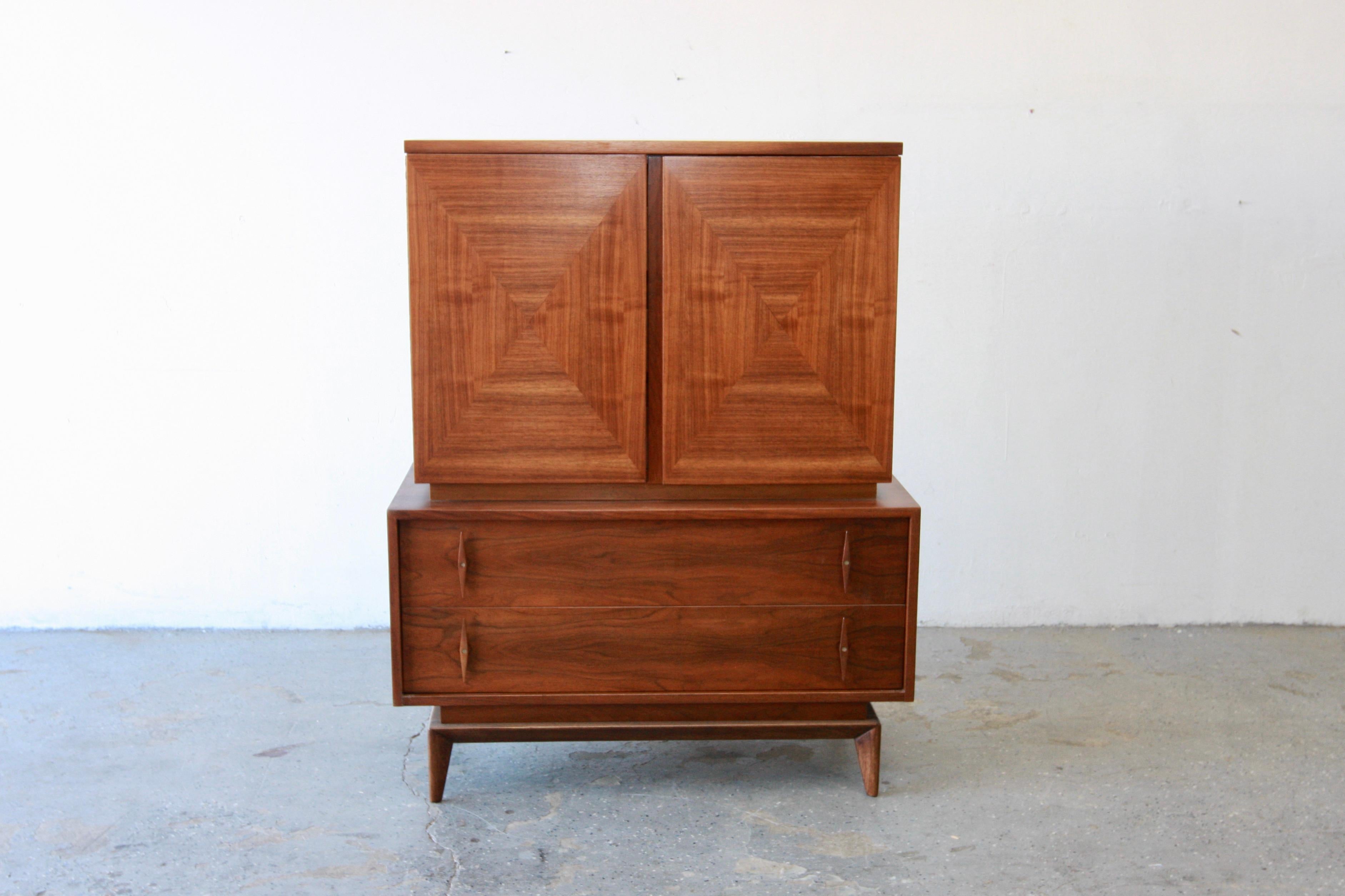 Mid century modern highboy/gentlemen’s chest by American of Martinsville. Here is a beautiful mid-century highboy dresser which has loads of storage for all your goodies! The top portion has two open doors, which house 3 wood drawers. As you can
