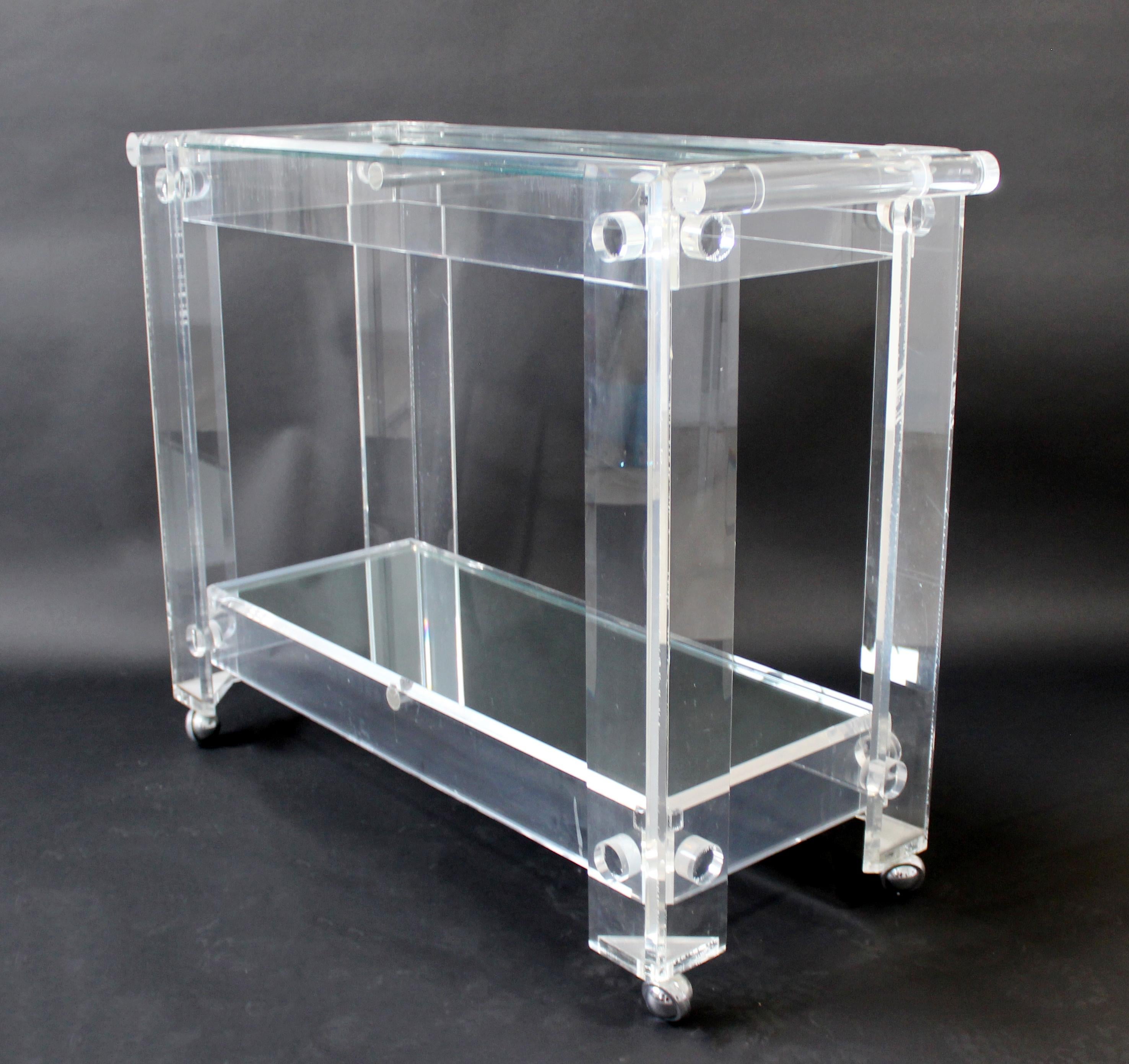 For your consideration is a fantastic, two tier, rolling bar or service cart, with two mirrored glass shelves, on a lucite base, by Charles Hollis Jones, circa the 1970s. In excellent vintage condition. The dimensions are 38.5