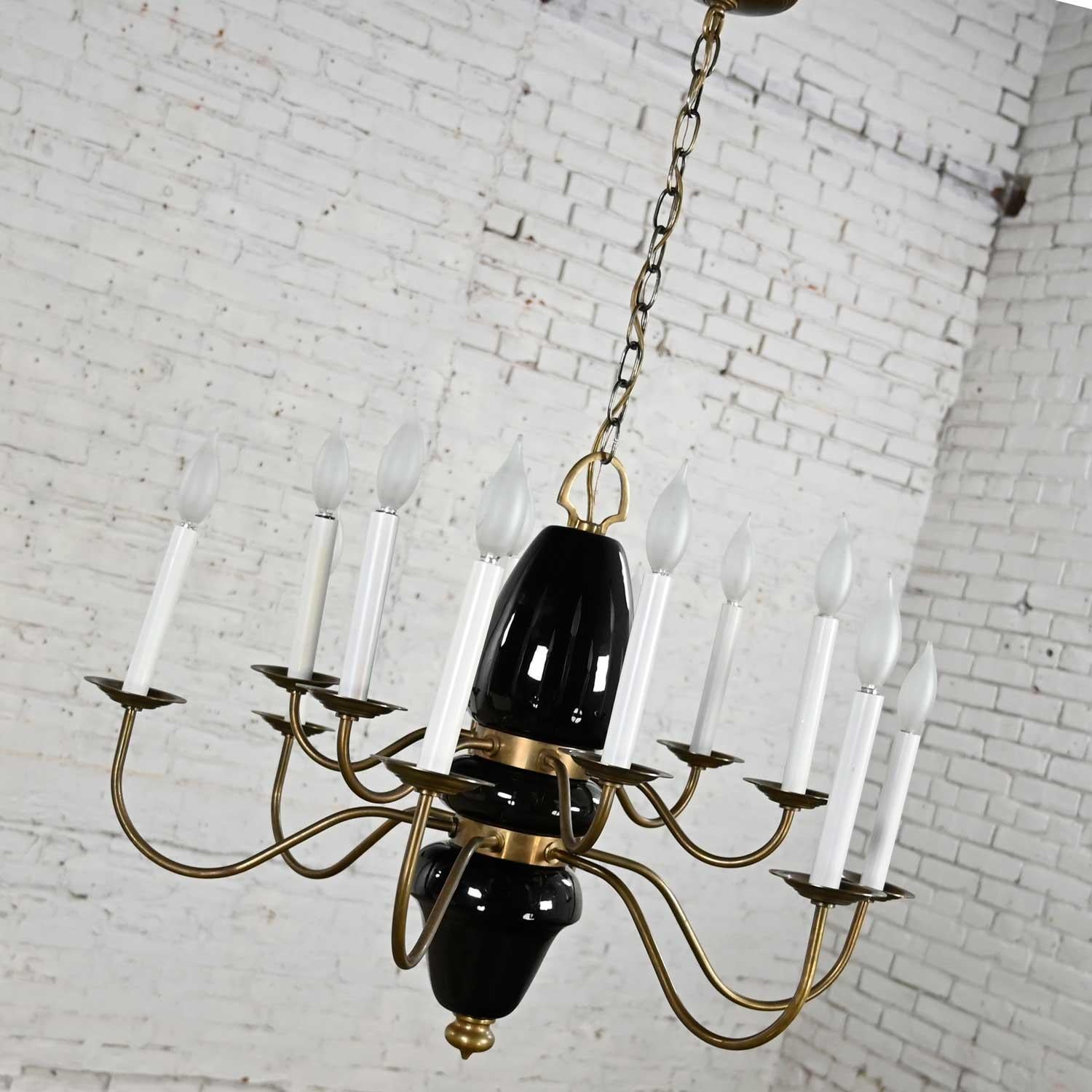 Marvelous Mid-Century Modern and a bit Hollywood Regency 12 arm black pottery & brass chandelier. Beautiful condition, keeping in mind that this is vintage and not new so will have signs of use and wear. The candle covers in the photos have been