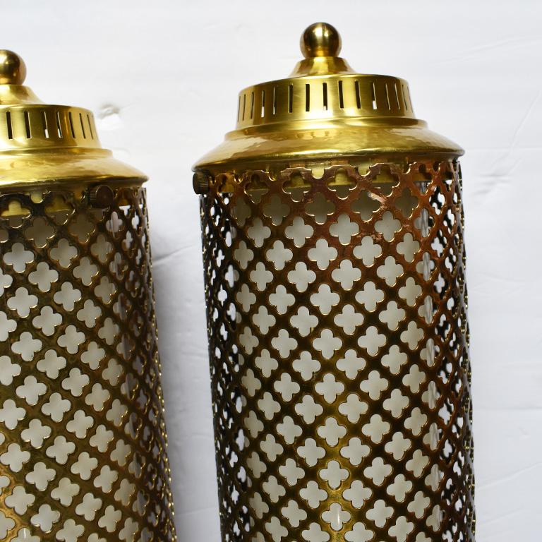Mid-Century Modern Hollywood Regency style pair of brass swag lights. This beautiful pair of hard wired chandelier lights will be a striking addition to any foyer, dining room or bathroom. Shaped in a conical shape, with quatrefoil cut patterns