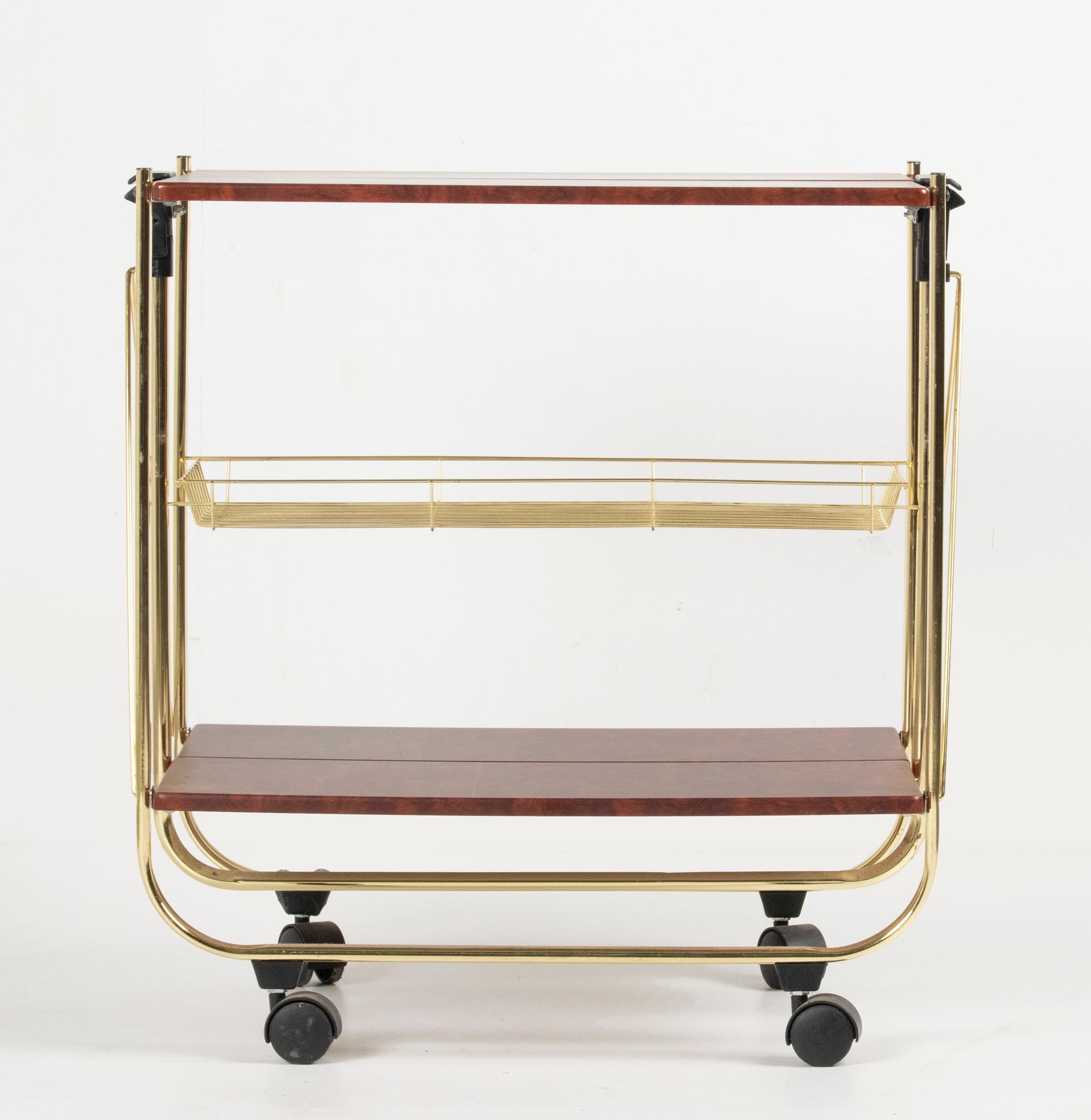 A vintage multifunctional French formica and polished brass folding serving cart. Made in France, 1970-1975. The trays are made of formica in imitation burl mahogany. In the middle an extra storage rack. In good condition.
Dimensions: 70 x 69 x 40