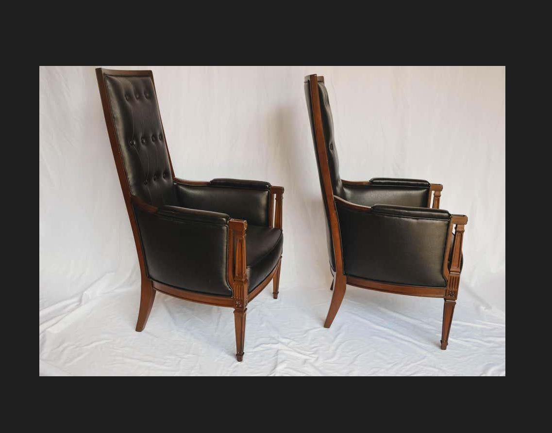 This is a wonderful pair of Mid-Century Modern Hollywood Regency armchairs. The high back, high style chairs have been newly upholstered in faux leather for durability. We love the tufted detail on the backs. A great pair of chairs to add modern