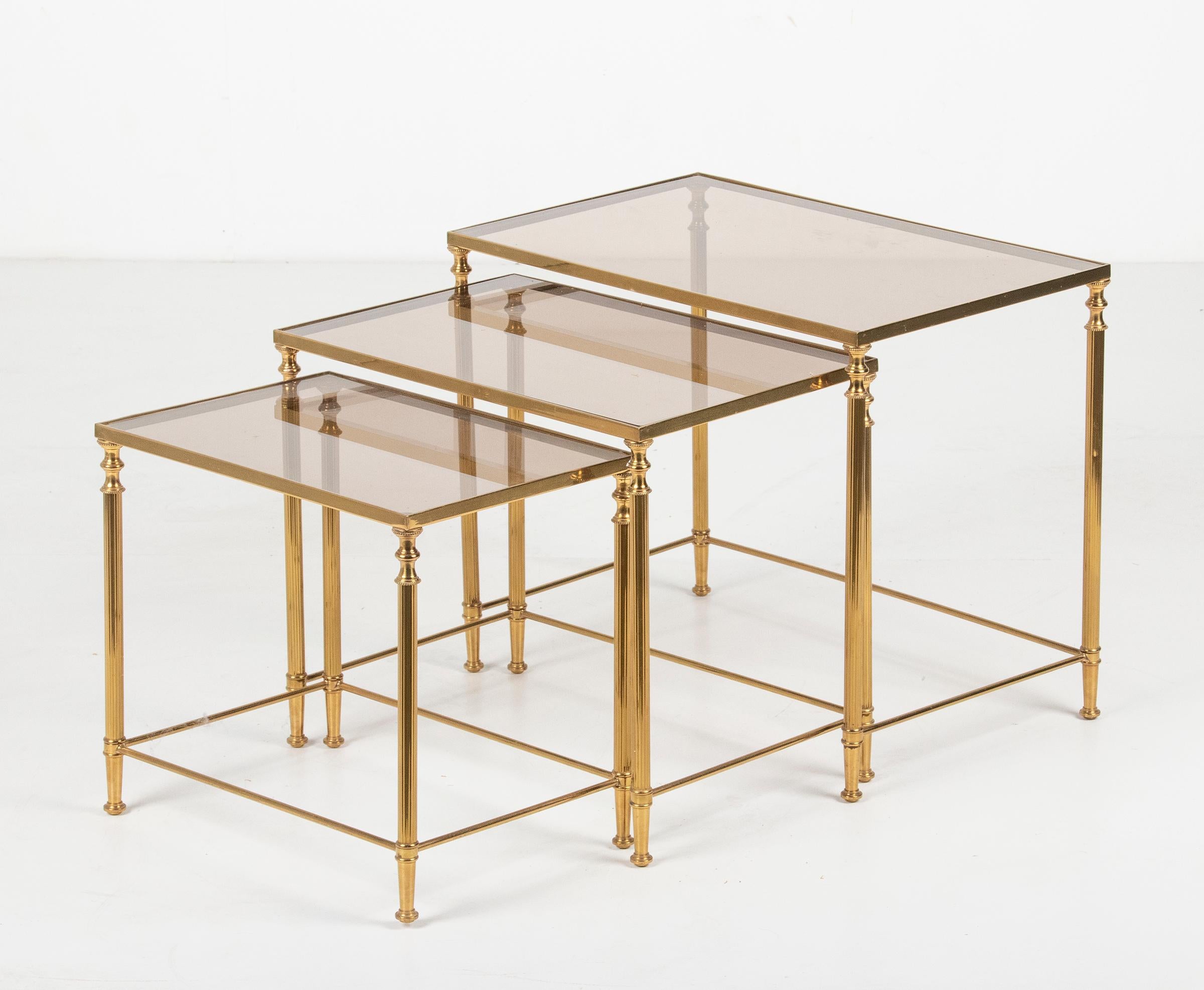 A set of three Hollywood Regency Brass nesting tables, with smoked glass tops. Resting on polished brass frames. Made in Belgium, circa 1960-1970. In very good vintage condition

Dimensions big: 43 x 54 x 33 cm
Dimensions middle: 39 x 45 x 30