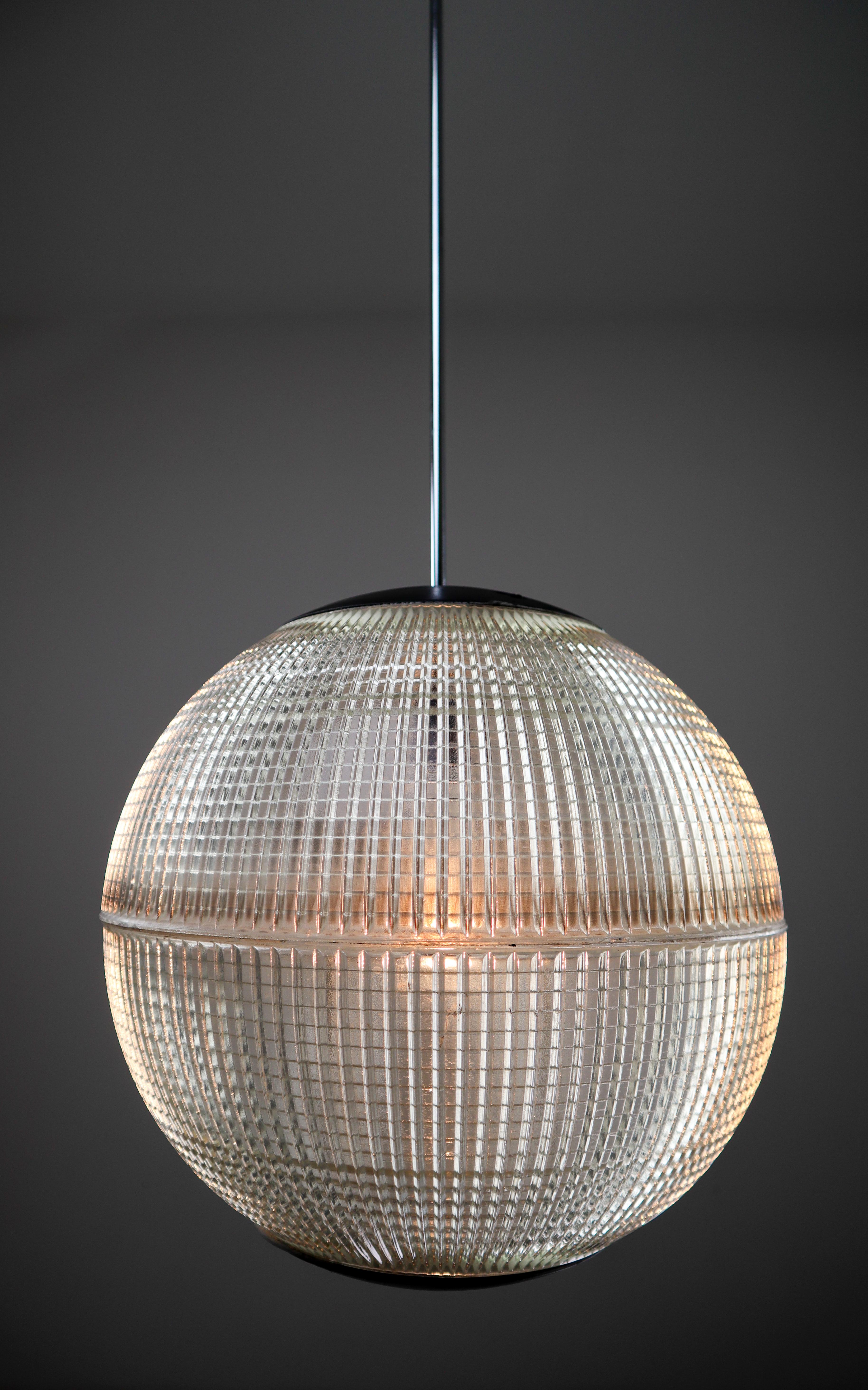 This is an original late 1960s Paris globe Holophane street light from Paris, France now turned into a pendant light. The hallmark of Holophane luminaries, or lighting fixtures, is the borosilicate glass reflector / refactor. The glass prisms (ribs)