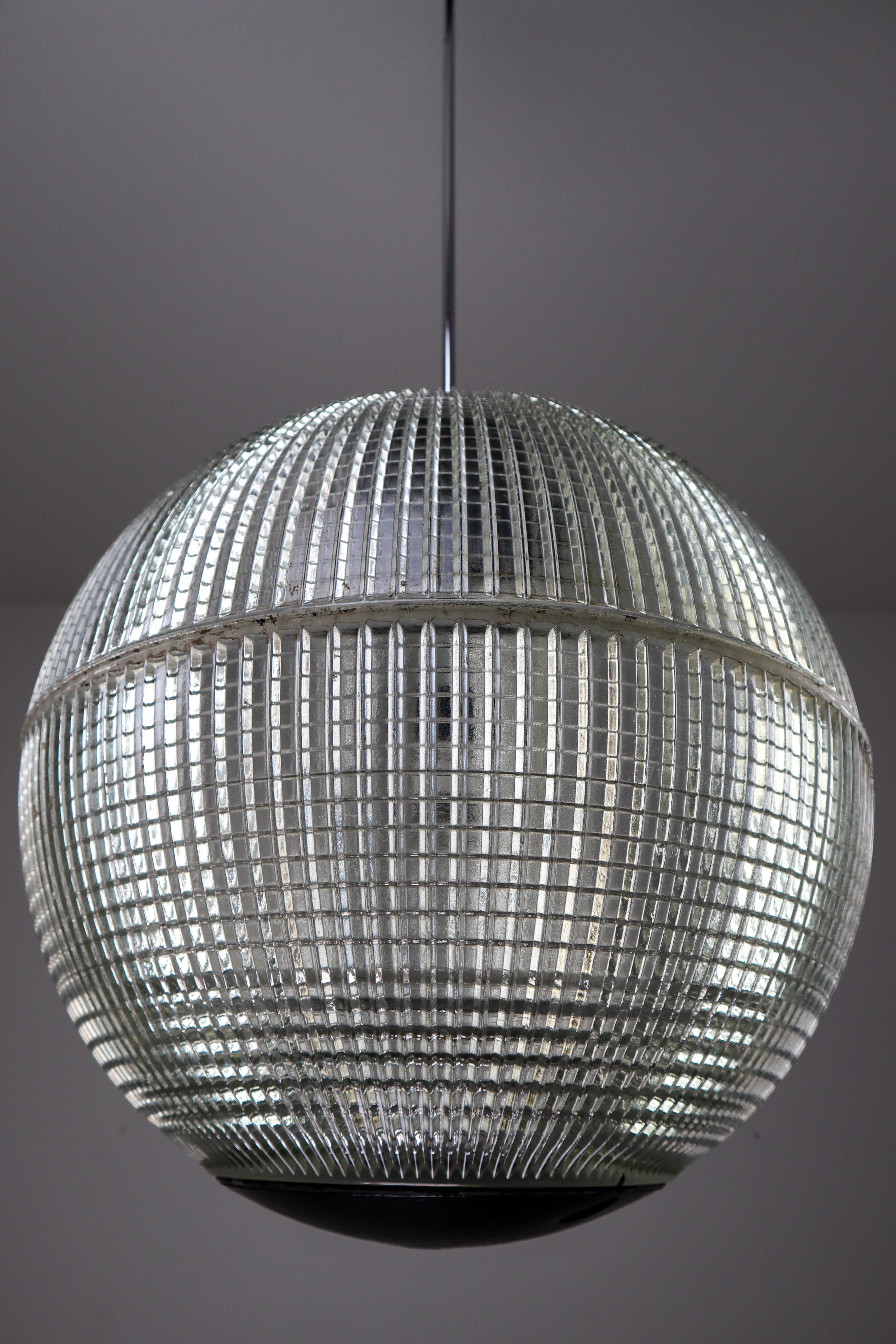 This is an original late 1960s Paris globe Holophane street light from Paris, France now turned into a pendant light. The hallmark of Holophane luminaries, or lighting fixtures, is the borosilicate glass reflector / refactor. The glass prisms (ribs)