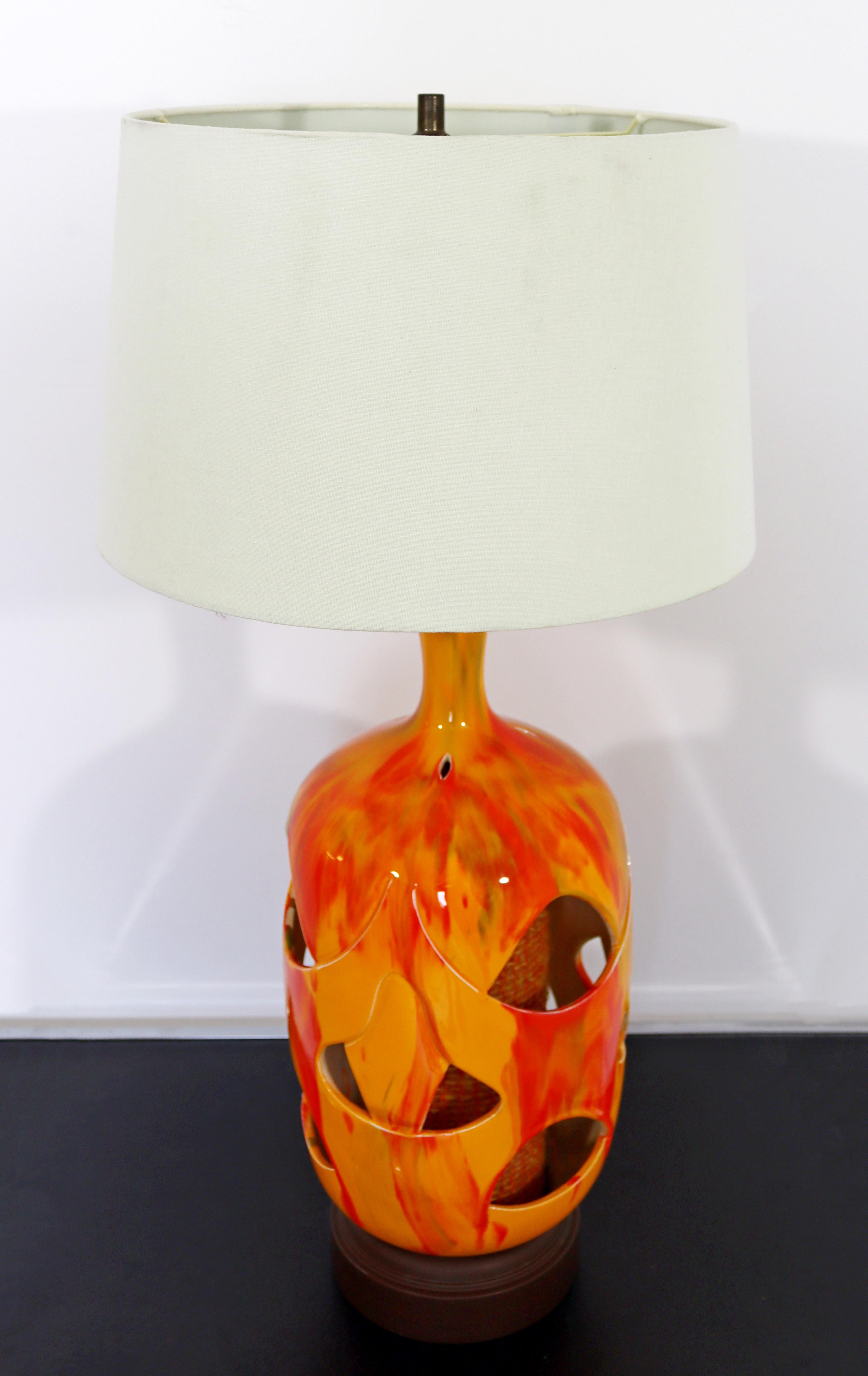 For your consideration is a fantastic, double light, lava drip glaze ceramic table lamp, with a fabric accent, and original finial, by Honi Chilo, circa the 1970s. In excellent vintage condition. The dimensions are 9