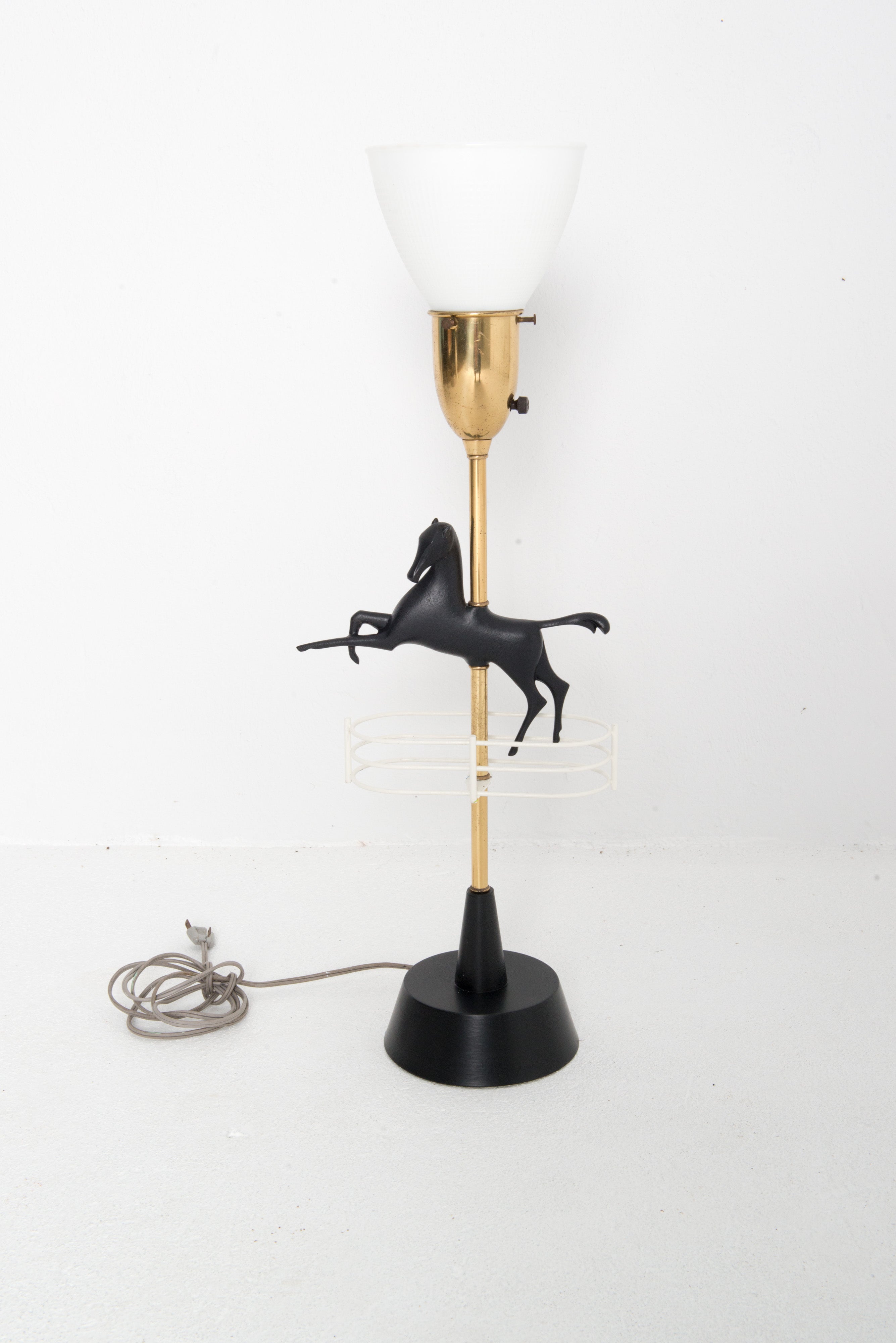 Mid century modern brass and painted metal leaping horse table lamp. Low cylindrical shade and glass diffuser are original to the lamp. Shade is 19