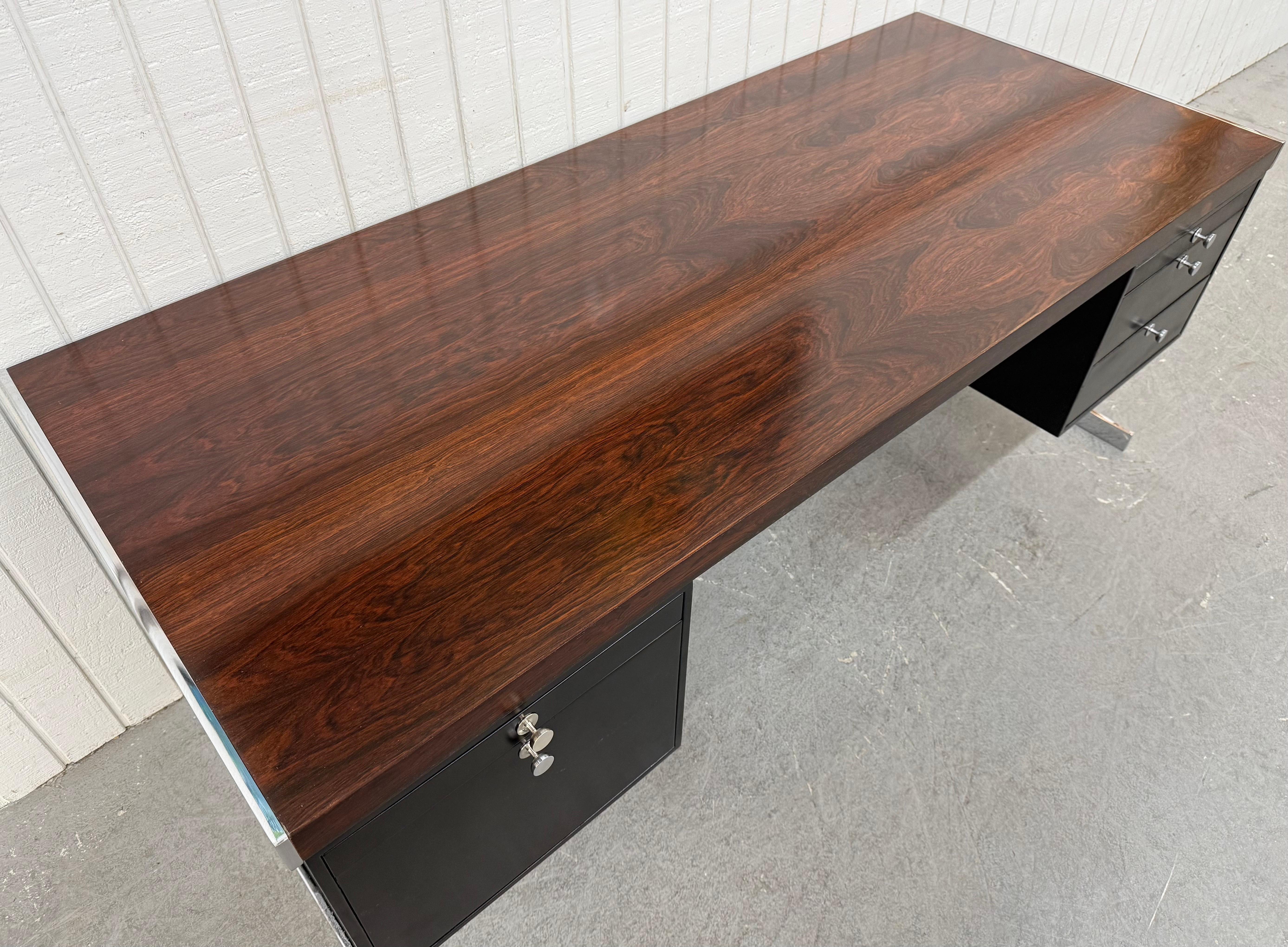 Questo annuncio si riferisce a una scrivania direzionale in legno di palissandro in stile Hugh Acton, moderna, di metà secolo. Il design è lineare, l'ampio piano rettangolare in palissandro, i mobiletti fluttuanti in metallo nero, le gambe cromate a