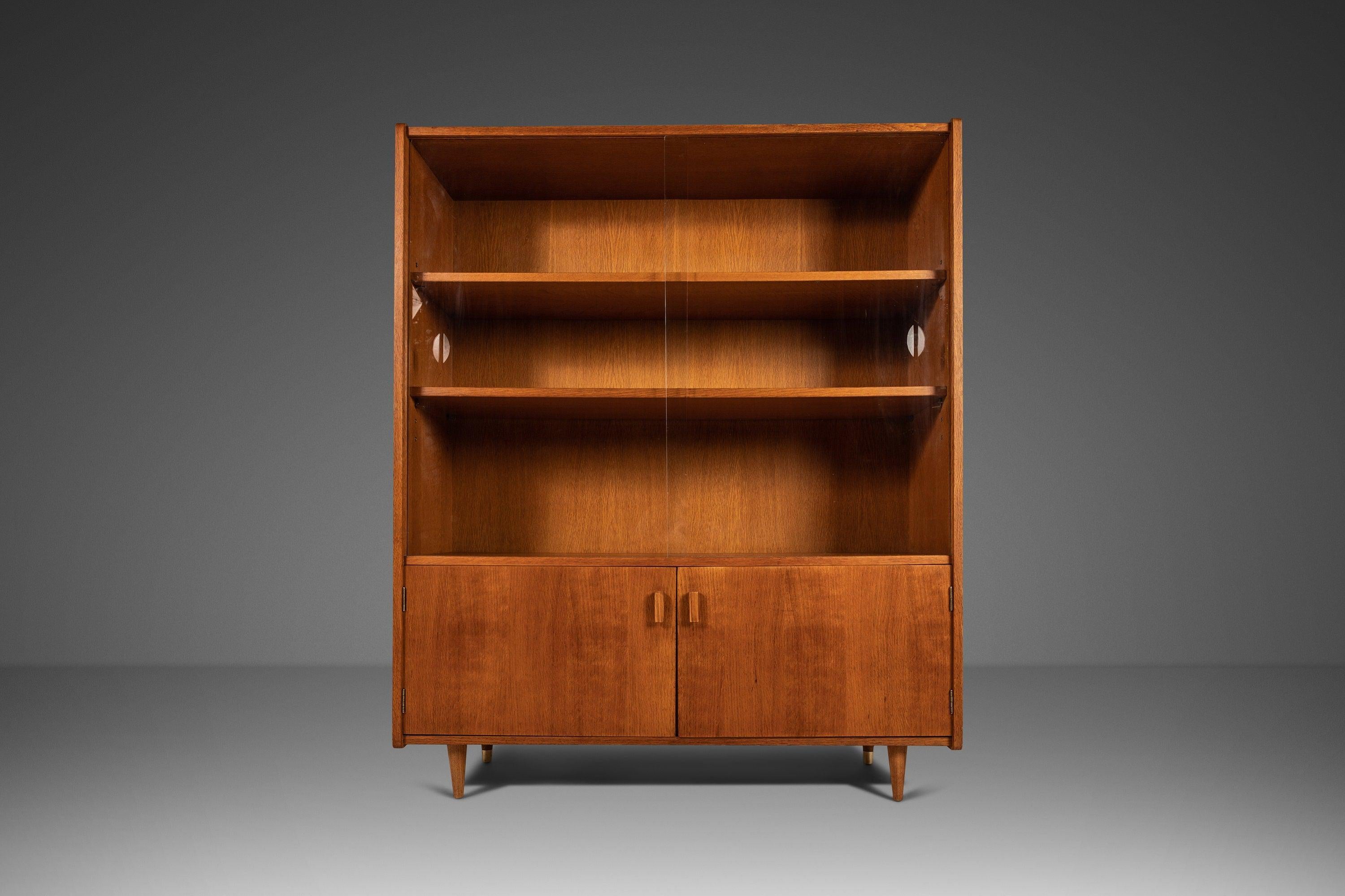 Petite yet substantial this splendid Mid Century Modern display cabinet is perfect for those who are limited on space but unwilling to compromise on style and functionality. Built from a mix of solid and veneered European walnut this cabinet is full