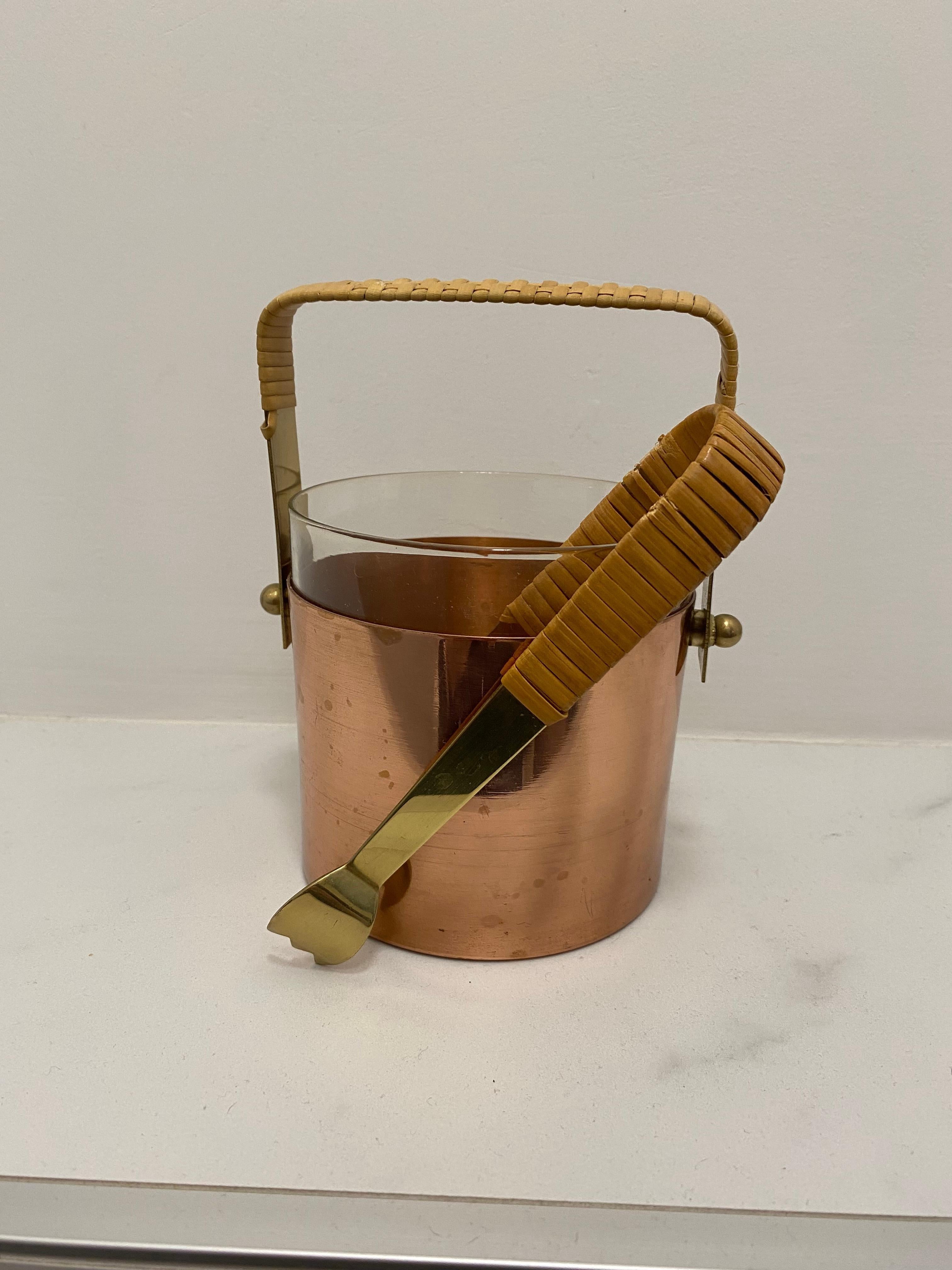 Muy bonita y elegante cubitera de los años 50/60 y viene con una pinza para hielo envuelta en ratán