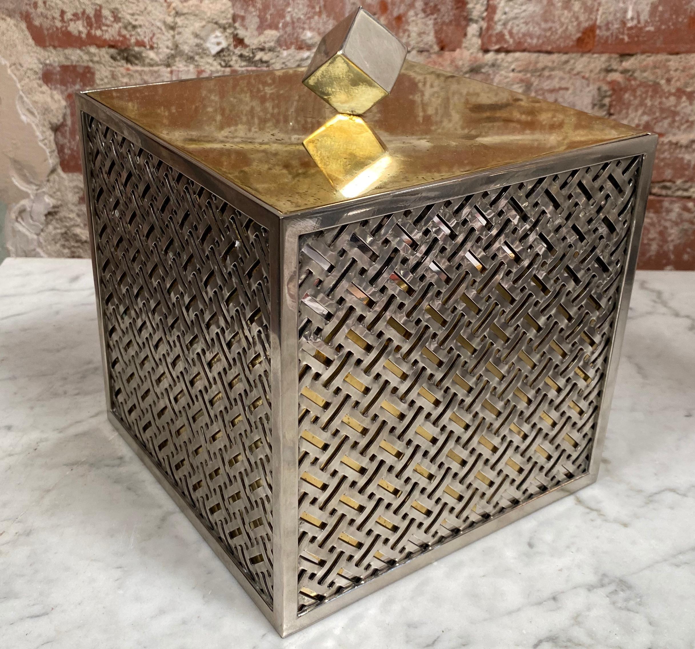 Vintage ice bucket made with brass chrome and plastic with cube detail on top.