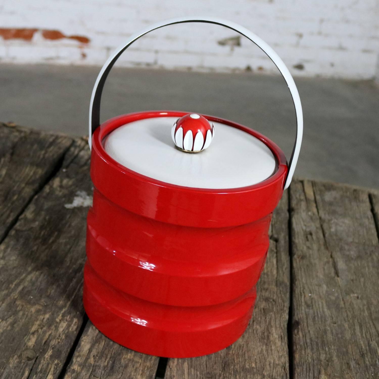 Fun vintage Mid-Century Modern red faux patent leather and white faux leather and plastic ribbed ice bucket with a mod red and white daisy knob. This fantastic ice bucket is in wonderful vintage condition, circa 1960s-1970s.

We just love this