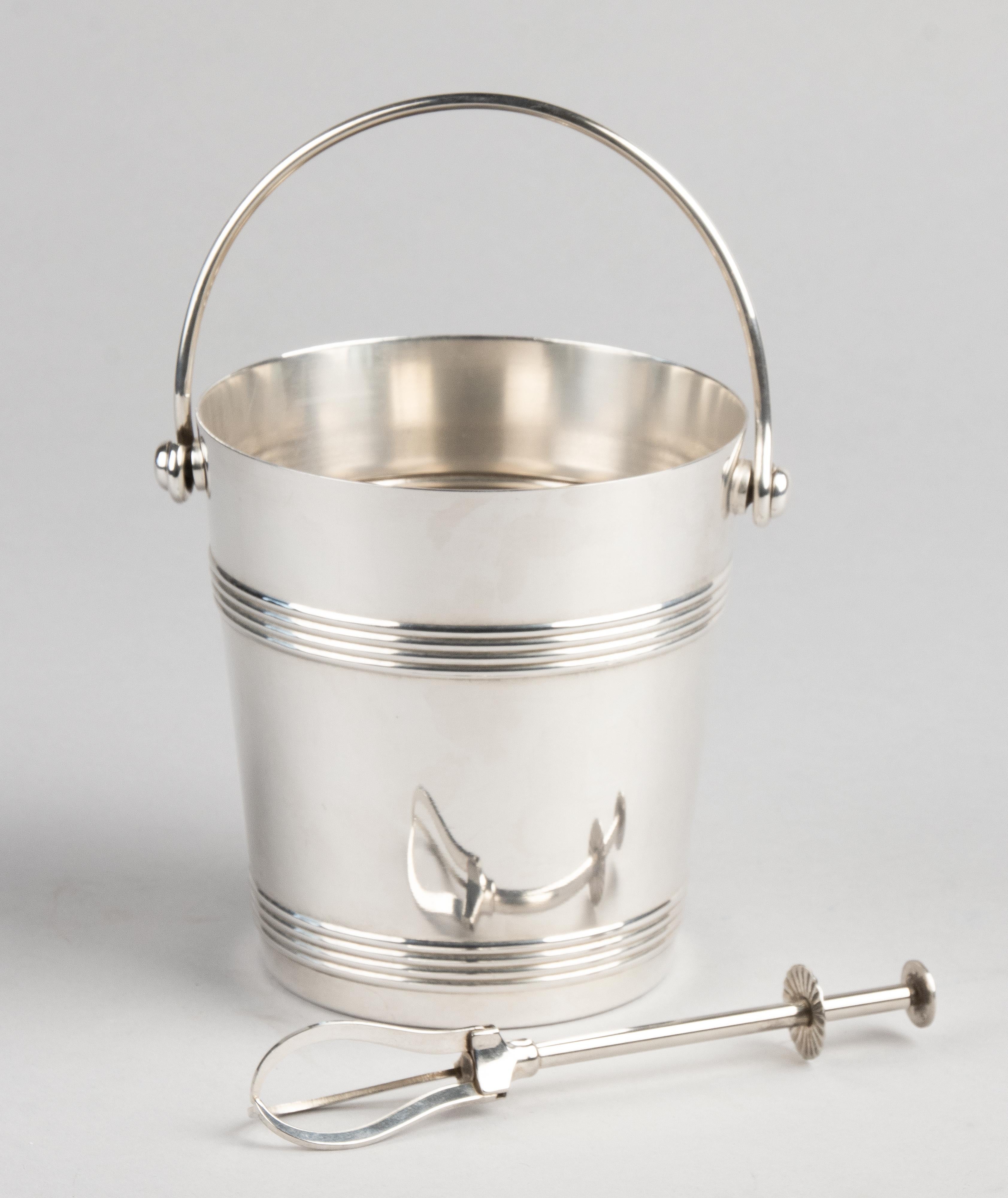 Beautiful silver plated bucket for ice cubes from the French brand Gallia (part of Christofle). On the bottom is a removable plate with holes, for leaking the ice cubes. The bucket is marked on the bottom.
This bucket comes with tongs for taking