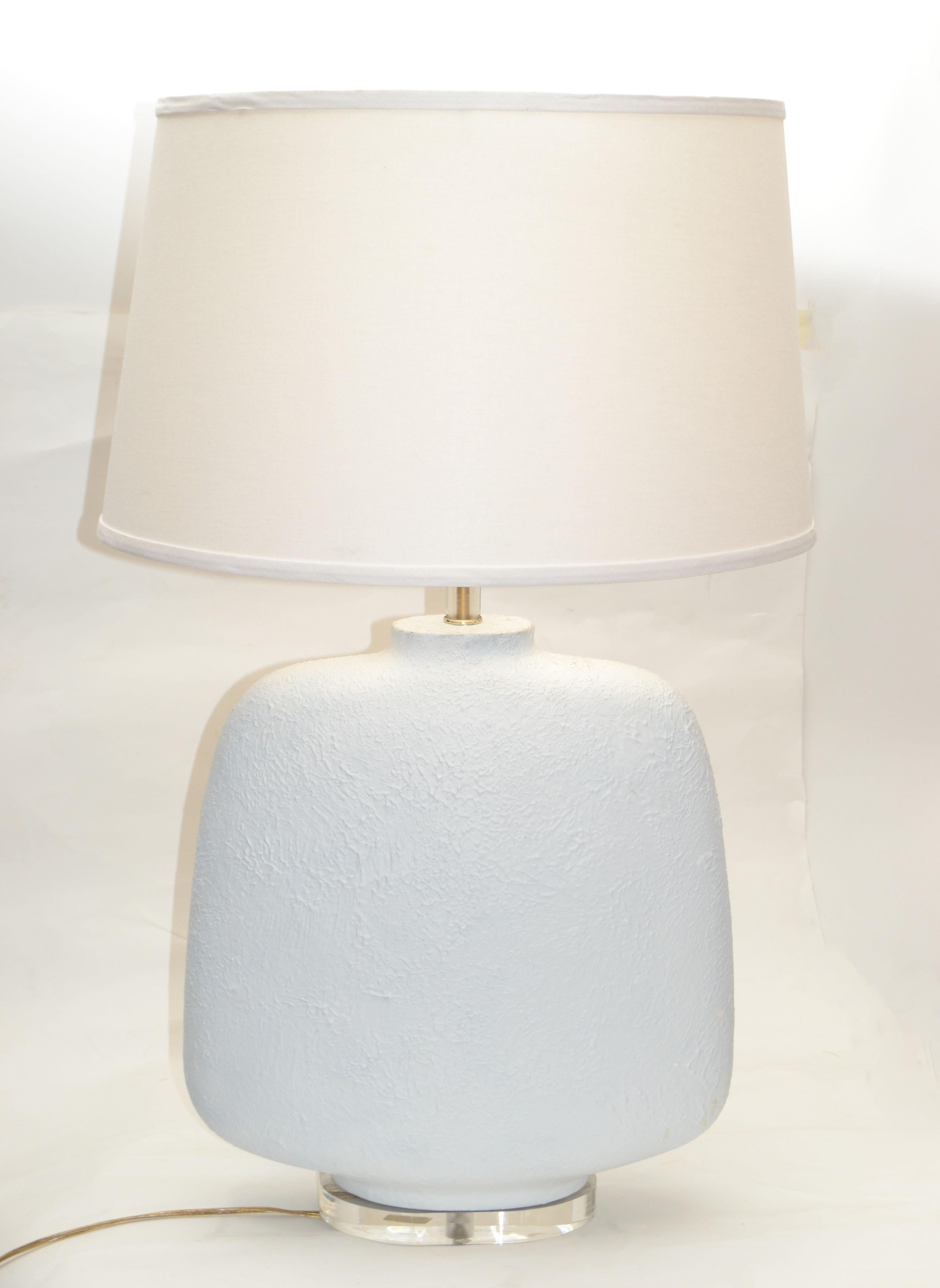 Mid-Century Modern table lamp with Harp & Finial. 
Plaster undertone with textured finish in a slim oval body & a chrome neck.
Lamp is supported by an oval 1-inch-thick Lucite Base.
US Rewired and takes a regular or LED Light Bulb.
Note: NO