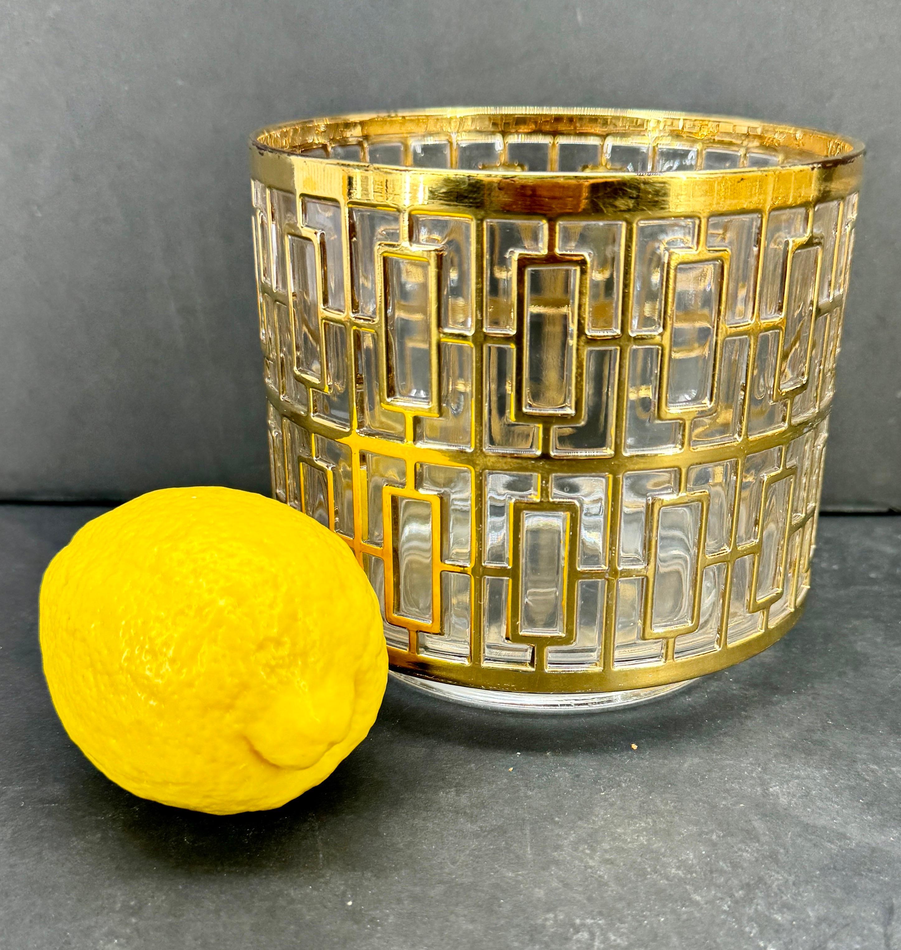 Gran colección de 14 piezas de cristalería de bar pintada a mano en oro de 22 quilates con el emblemático diseño Shoji de Imperial Glass Company, década de 1960. 
El set incluye 6 vasos de roca, 7 vasos highball y una cubitera, que también puede