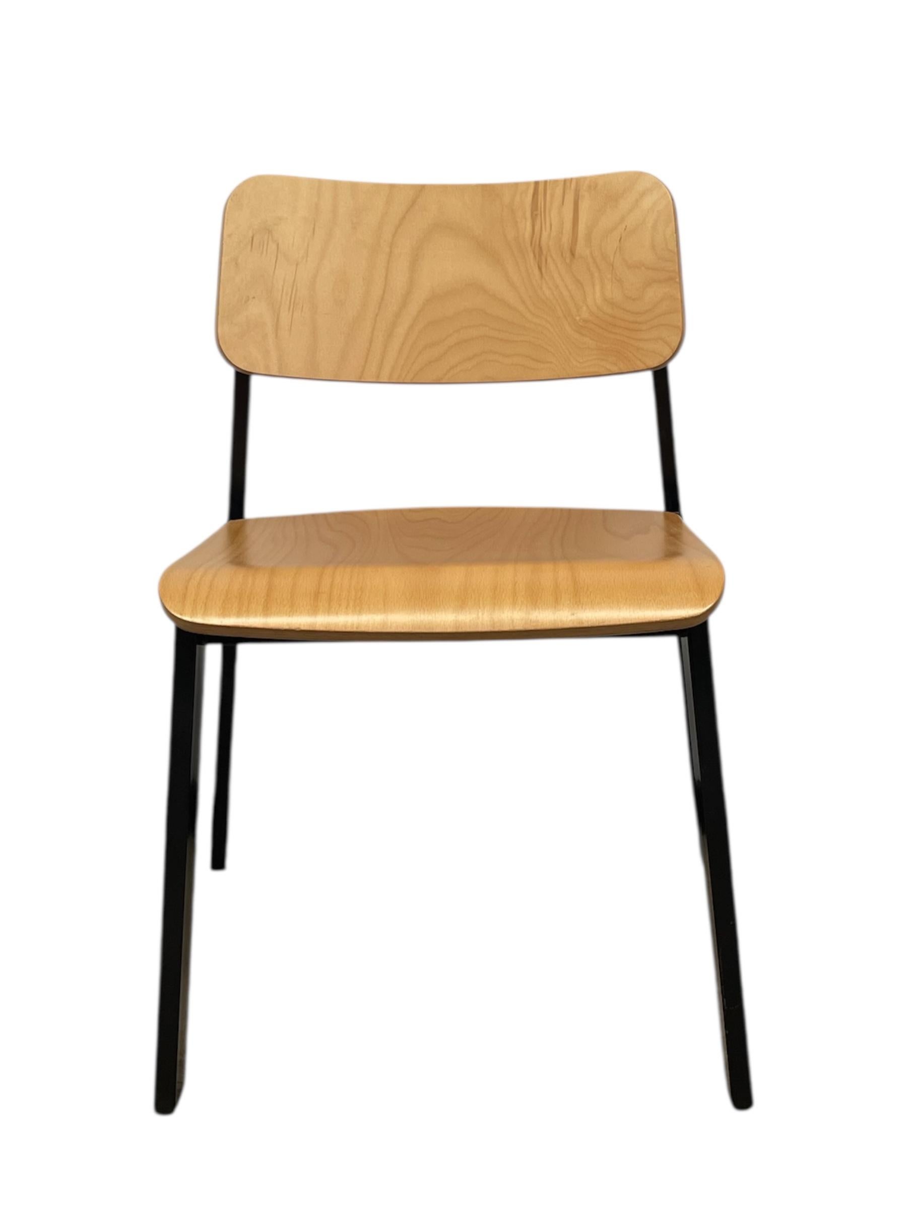 This vintage stacking chair combines utilitarian function with classic mid-century modern design. The seat and backrest are formed from molded plywood with a warm, natural finish that highlights the wood grain. The gentle curve of the backrest and