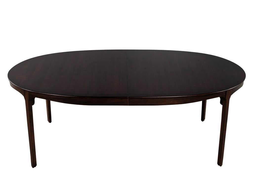 Mid-Century Modern inspired American walnut dining table. Sleek mid-century design with beautiful walnut grain pattern. Finished in a dark walnut satin color. Table can extend using single leaf.

Measures: Table cosed W: 84