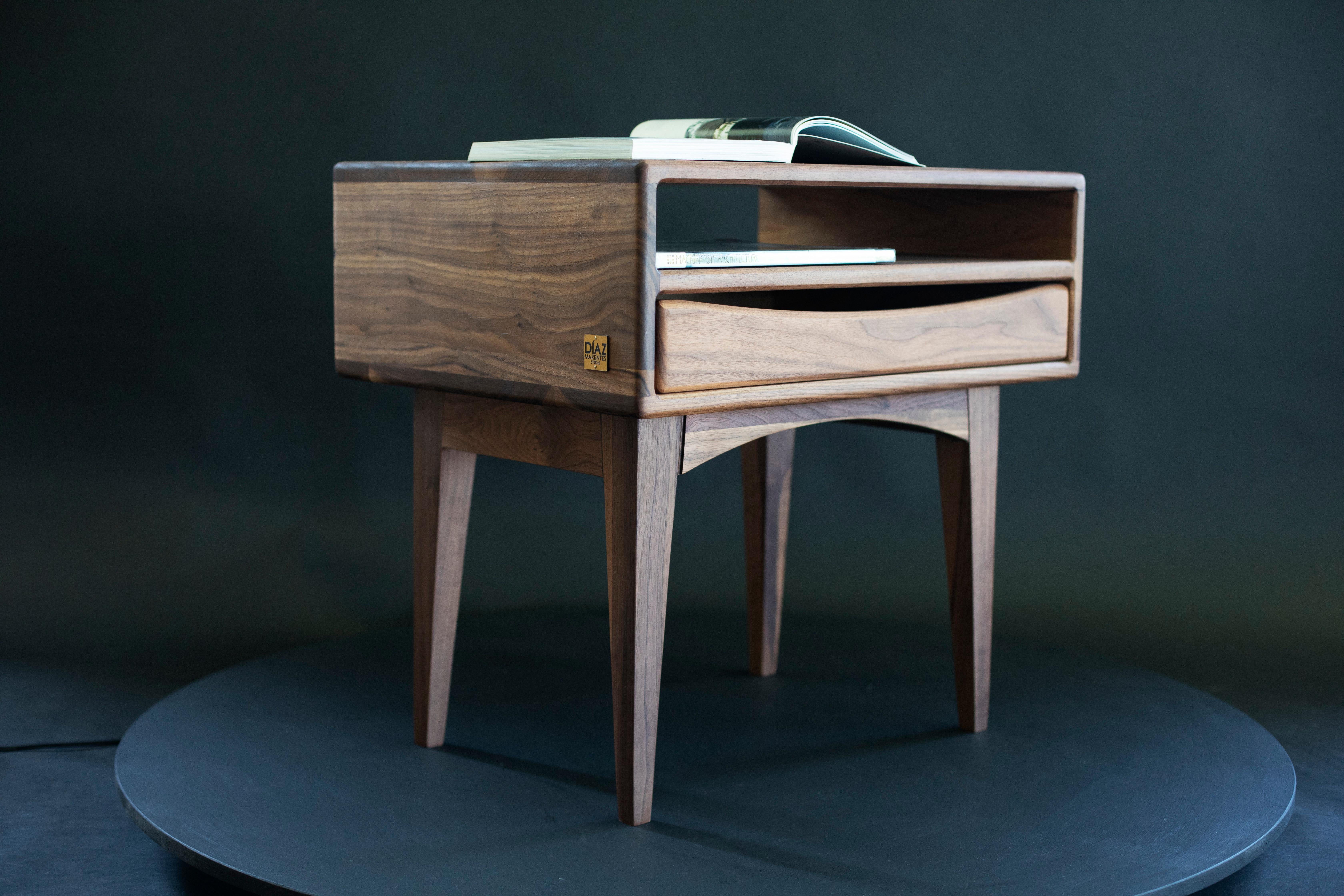 Table de nuit artisanale en noyer avec tiroir flottant - Mid-Century Modern Design

Ancrée dans l'héritage de l'artisanat scandinave du 20e siècle, cette table de nuit en noyer fabriquée à la main réinterprète la géométrie épurée et la matérialité