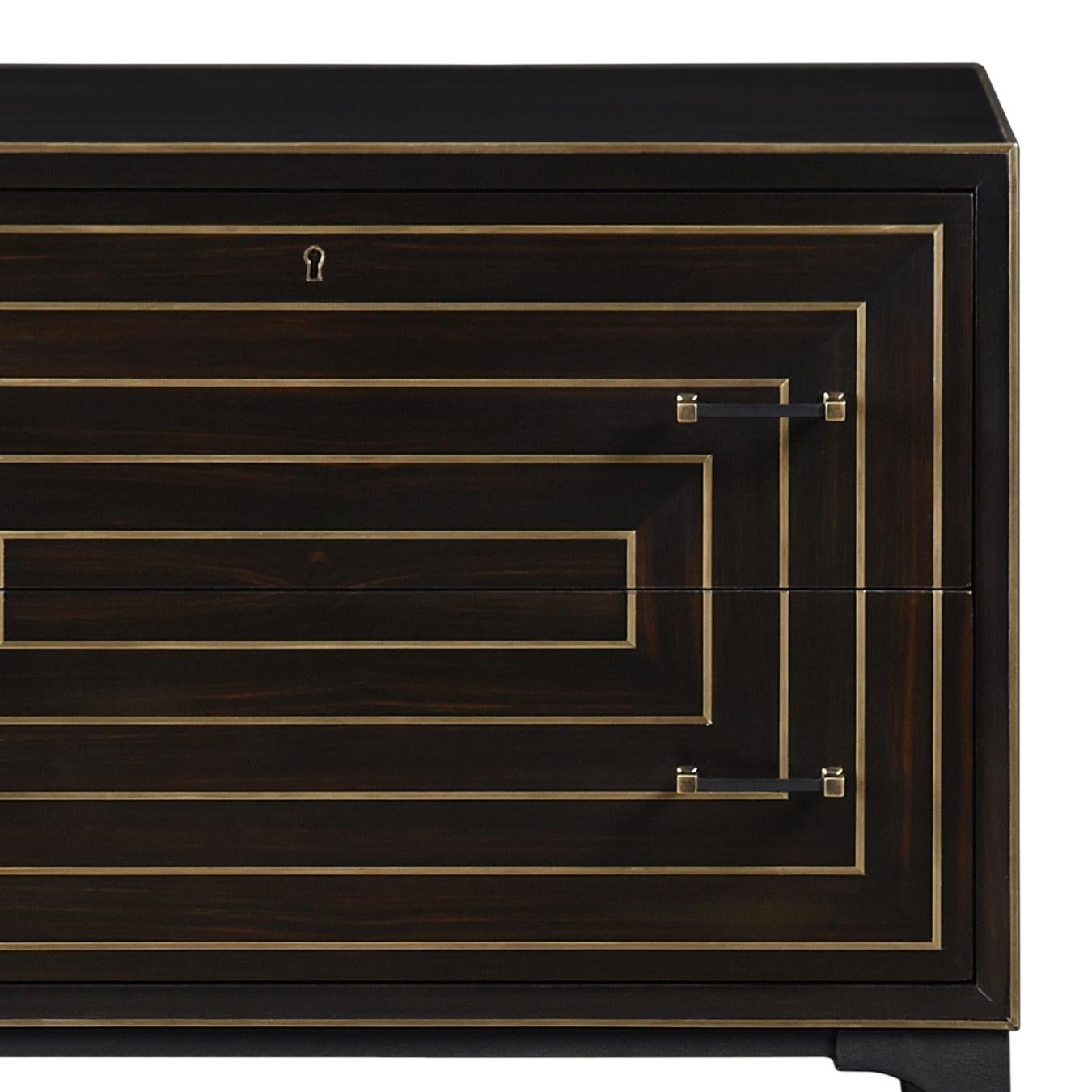 Il comodino Limoge è un pezzo molto elegante con influenze Mid-Century Modern. Realizzato in ebano, presenta incrostazioni in ottone e gambe affusolate in metallo. La sua silhouette semplice e la sua decorazione sofisticata lo rendono un pezzo senza