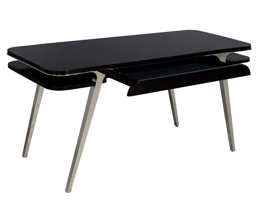 Mid-Century Modern inspired polished stainless steel desk. Featuring a sleek modern design with single drawer and cutout storage shelves. Finished in a rich hand rubbed ebony color.

Price includes complimentary curb side delivery to the