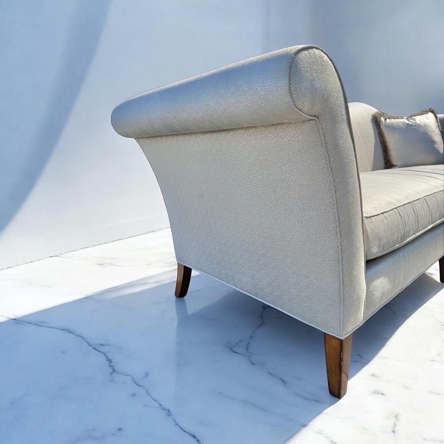 Questo annuncio si riferisce a un divano imbottito ispirato al Mid-Century Modern Theodore Alexander. Caratterizzato da uno schienale color cammello, braccioli arrotolati, ampio cuscino in piuma, cuscini d'accento e gambe in stile MCM. Questa è