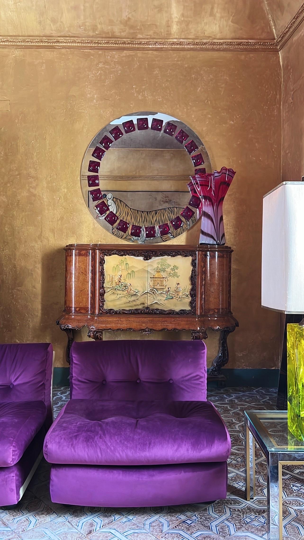 This stunning mirror titled Perfect Imperfect Mirror is created and signed by Swedish artist Amanda Malm.

The artwork is defined by its distinctive frame composed of 24 deep red fused glass pieces. Each element is individually crafted carrying