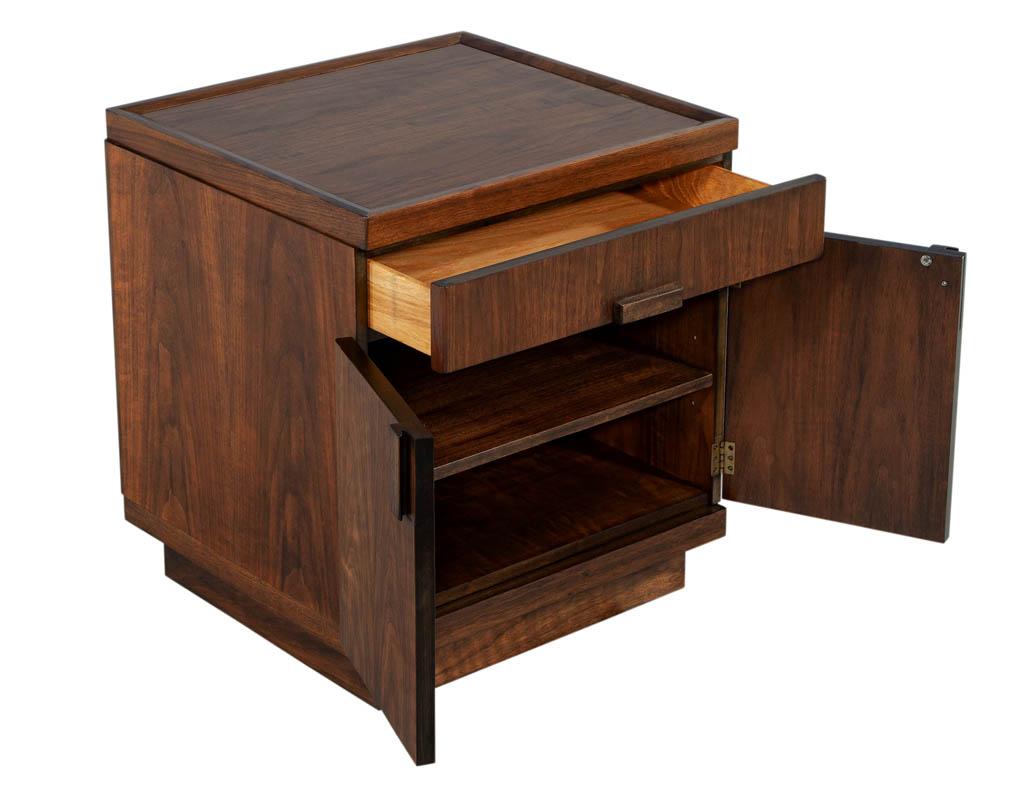 Mid-Century Modern inspired walnut end table chest. Finished in a satin medium brown walnut finish. Featuring large top for accessories and ample storage solutions with single drawer and 2 door compartment. Composed of walnut woods and manufactured