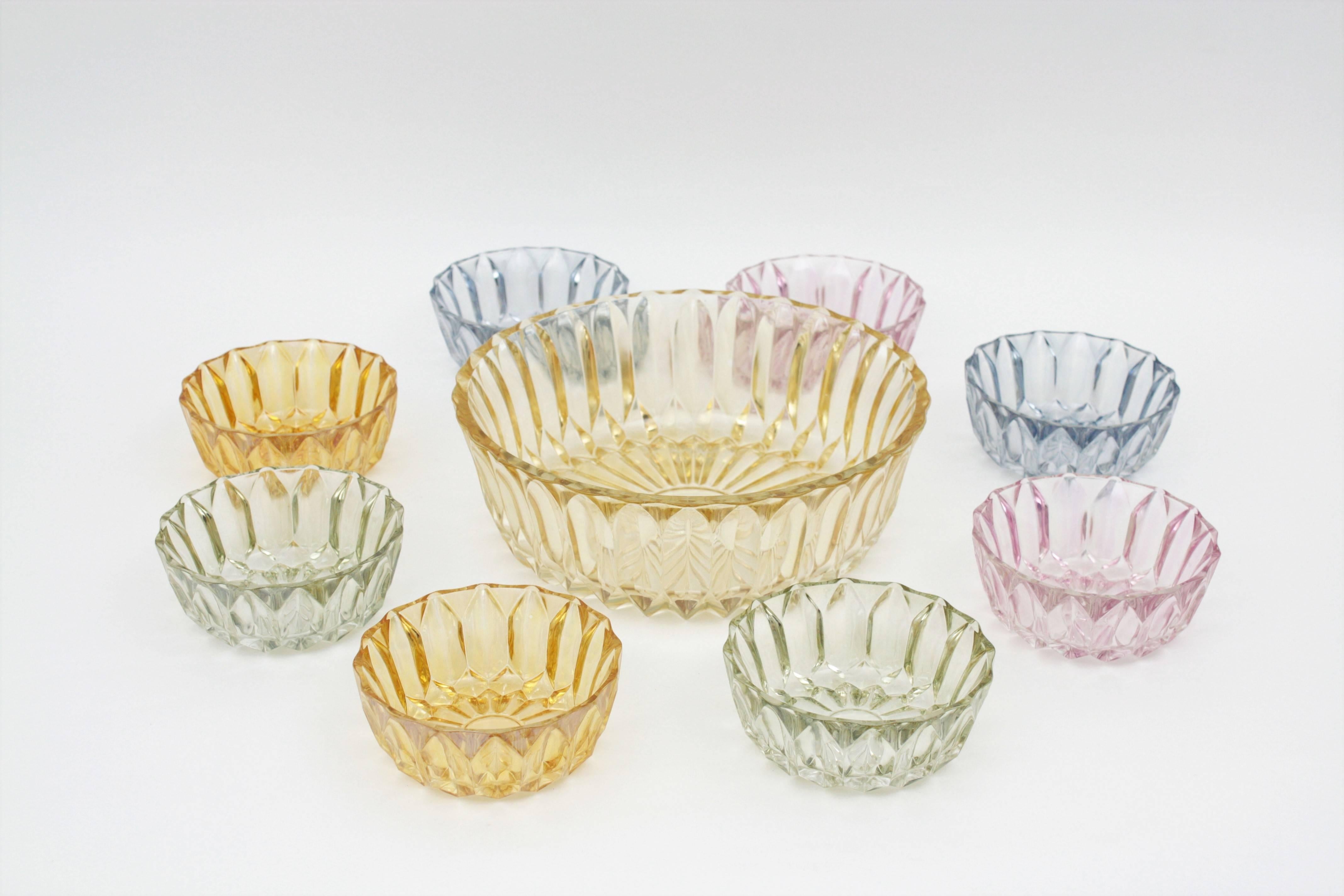 A colorful set of eight pretty pastel color pressed pattern glass round bowls and a large bowl / centerpiece. Spain, 1960-1970.
Each pair of bowls in different colors, pink, blue, green and amber with a pressed pattern that gives to the set a