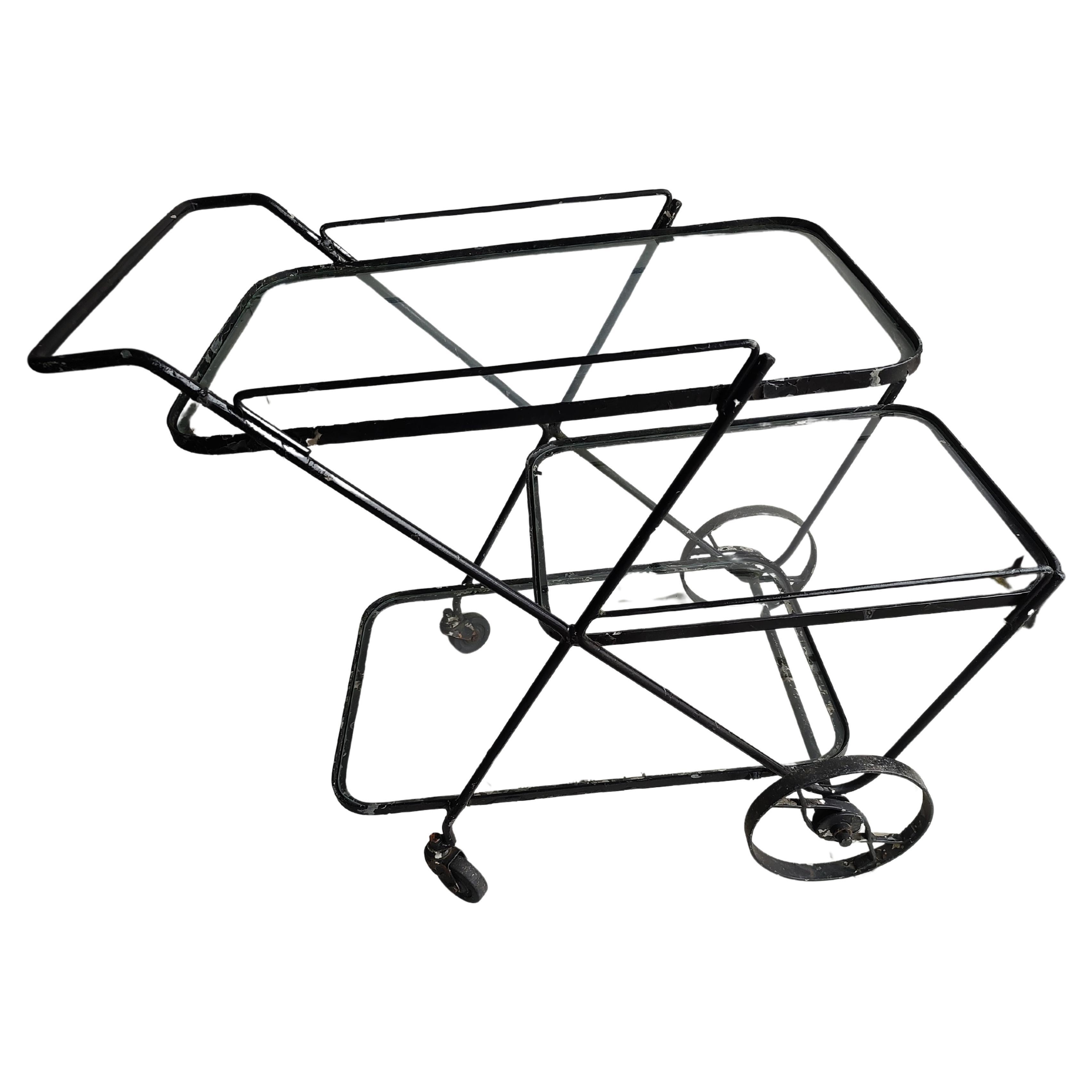 Fabulous minimalist bar cart from the early fifties. 3 Tiers of glass shelving, 2 new pieces of glass. Shelves are 26.5 x 16.25 2pieces and one piece 22.25 x 16.25. In excellent vintage condition with minimal wear could use some paint. Wheels