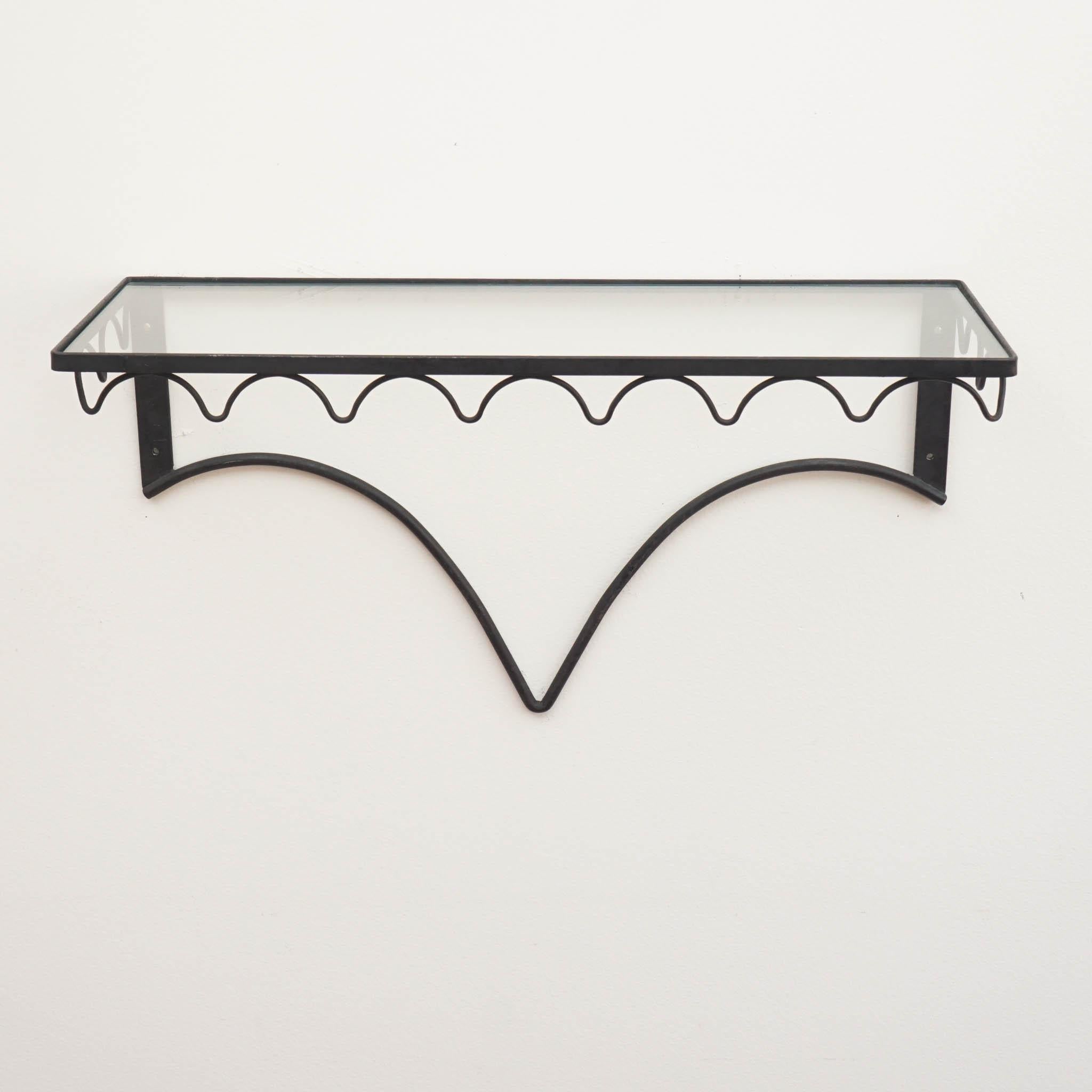 Add a touch of mid-century sophistication to your space with these floating shelves. Crafted from sturdy iron, the black finish adds a contemporary edge and complements a variety of styles. Each shelf comes with a tempered glass insert, providing a