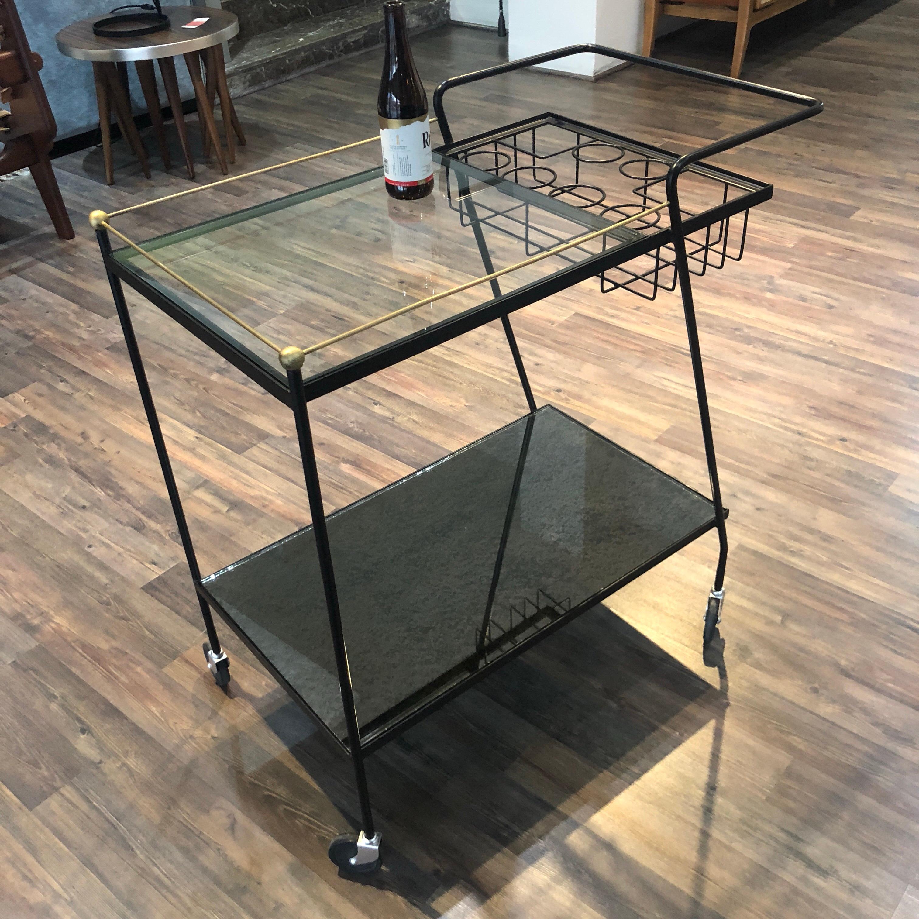 Iron bar cart with brass accents, the first cover is made of glass and the one on the bottom is an aged mirror, the style is very similar to Pani's designs but without confirming its authorship.