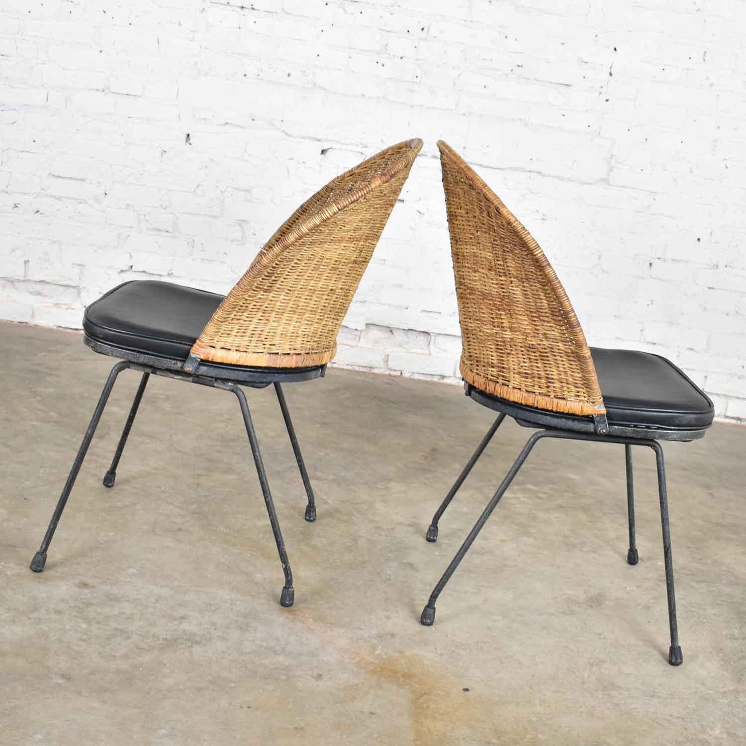 Handsome and unusual pair of Mid-Century Modern iron and wicker barrel back Neva-Rust chairs designed by Maurizio Tempestini for John Salterini. They are in wonderful vintage condition. They retain their original black finish, but it is not without