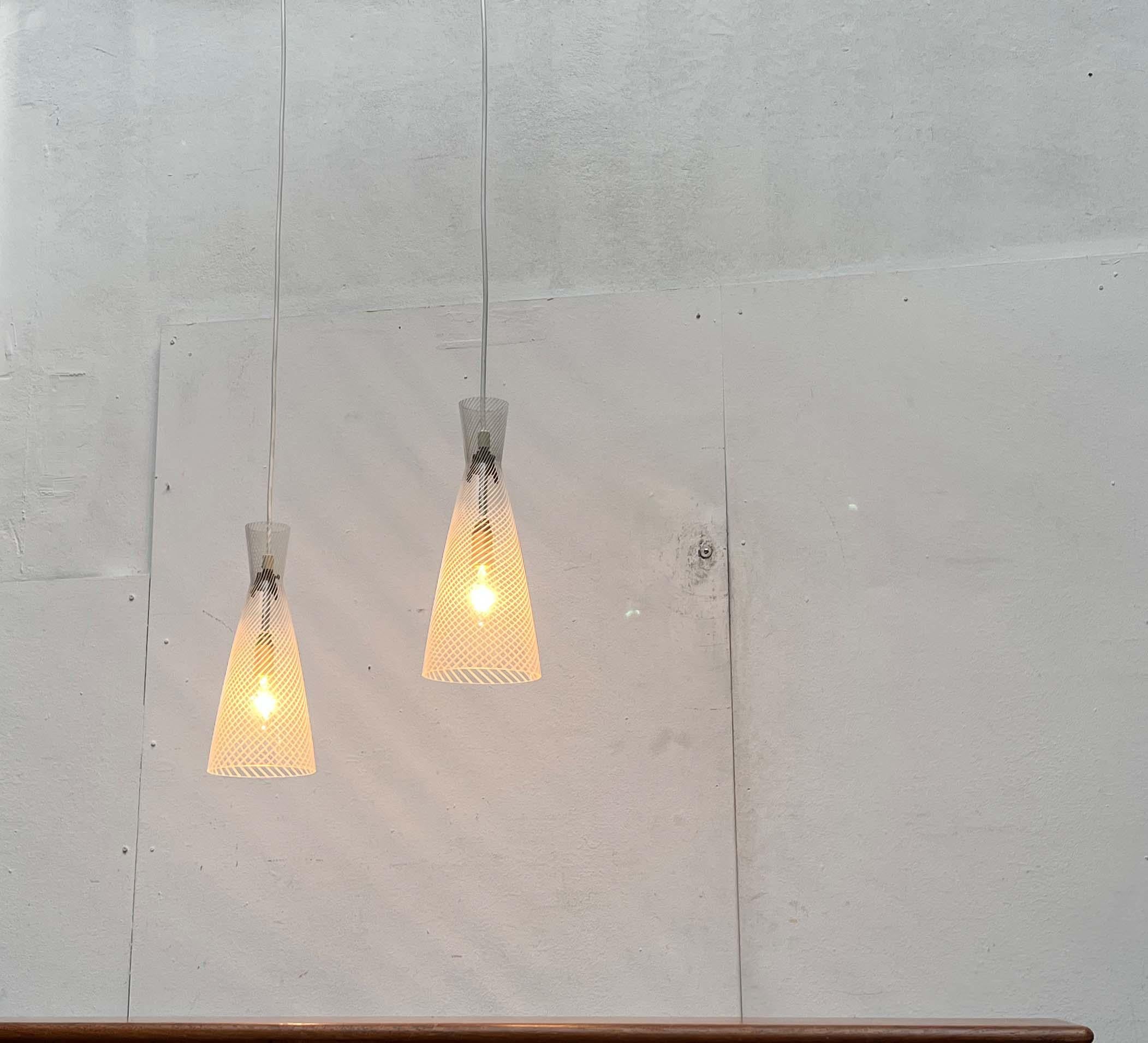 Impressionanti lampade a sospensione in vetro di metà secolo di Peill & Putzler, basate su un disegno di
Aloys Ferdinand Gangkofner degli anni '50. Qui in una rara versione con vetro trasparente.

Il design colpisce per il suo gioco di trasparenze e