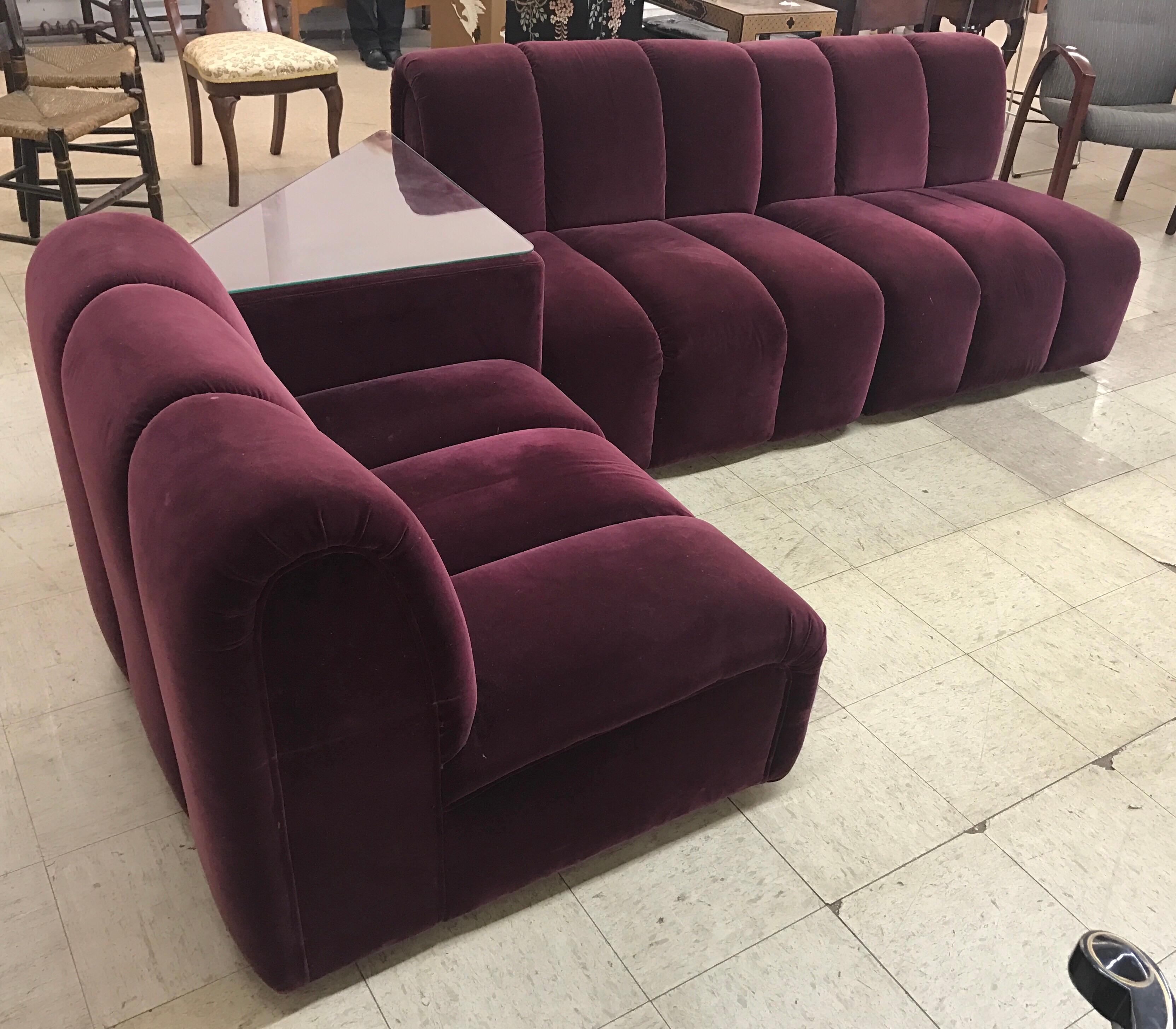 Stunning modular four piece sectional sofa, circa 1972 Italy. Fabric is special, a luxurious velvet burgundy.
The piece consists of four pieces with one being a triangular table and the other three being seats that can be reconfigured as you like.
