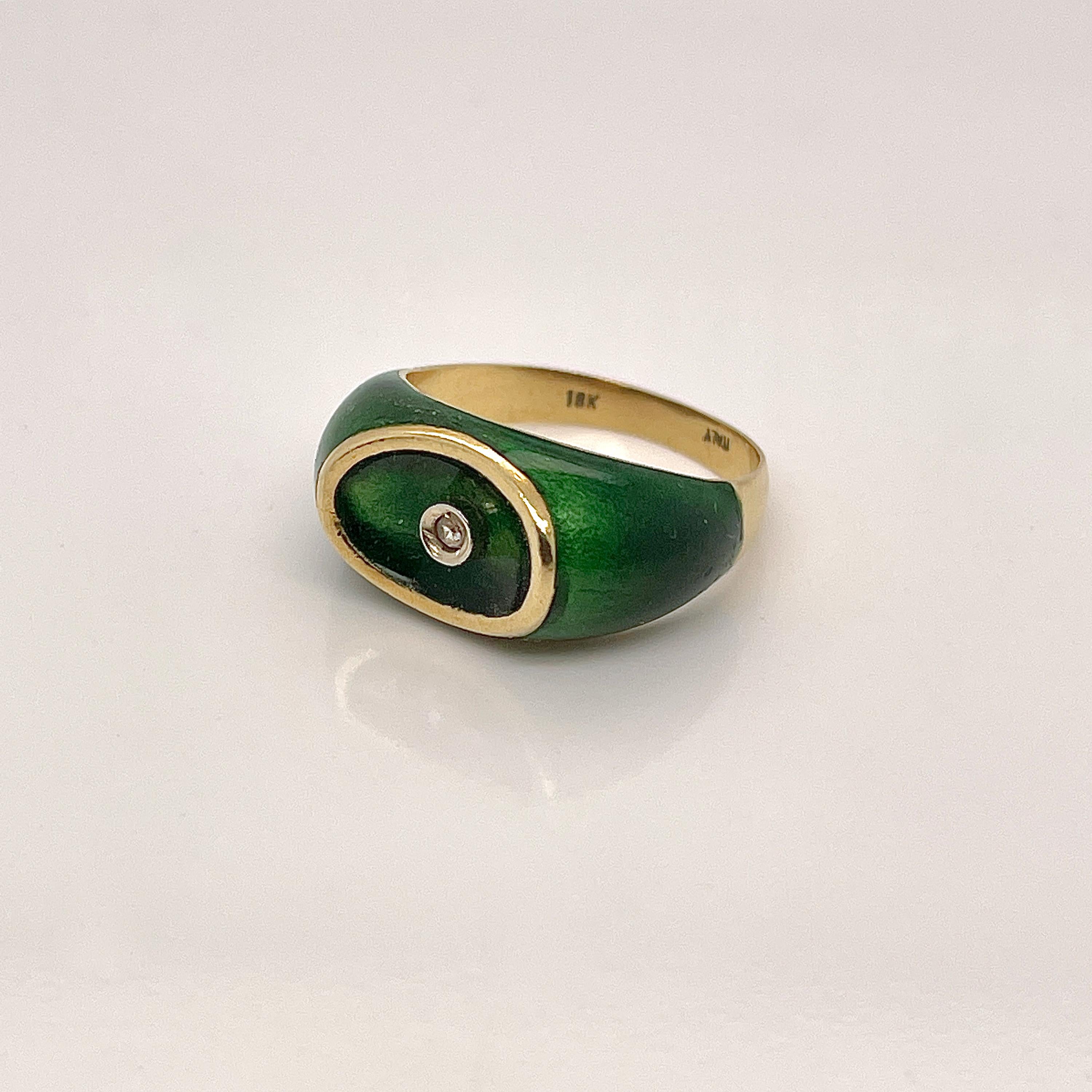 A very fine Italian gold and green enamel signet ring.

In 18k yellow gold. 

With a bezel set tiny, round aquamarine in center and enamel with green vitreous enamel to the head and shoulders. 

The top of the signet ring is oval shaped with an oval