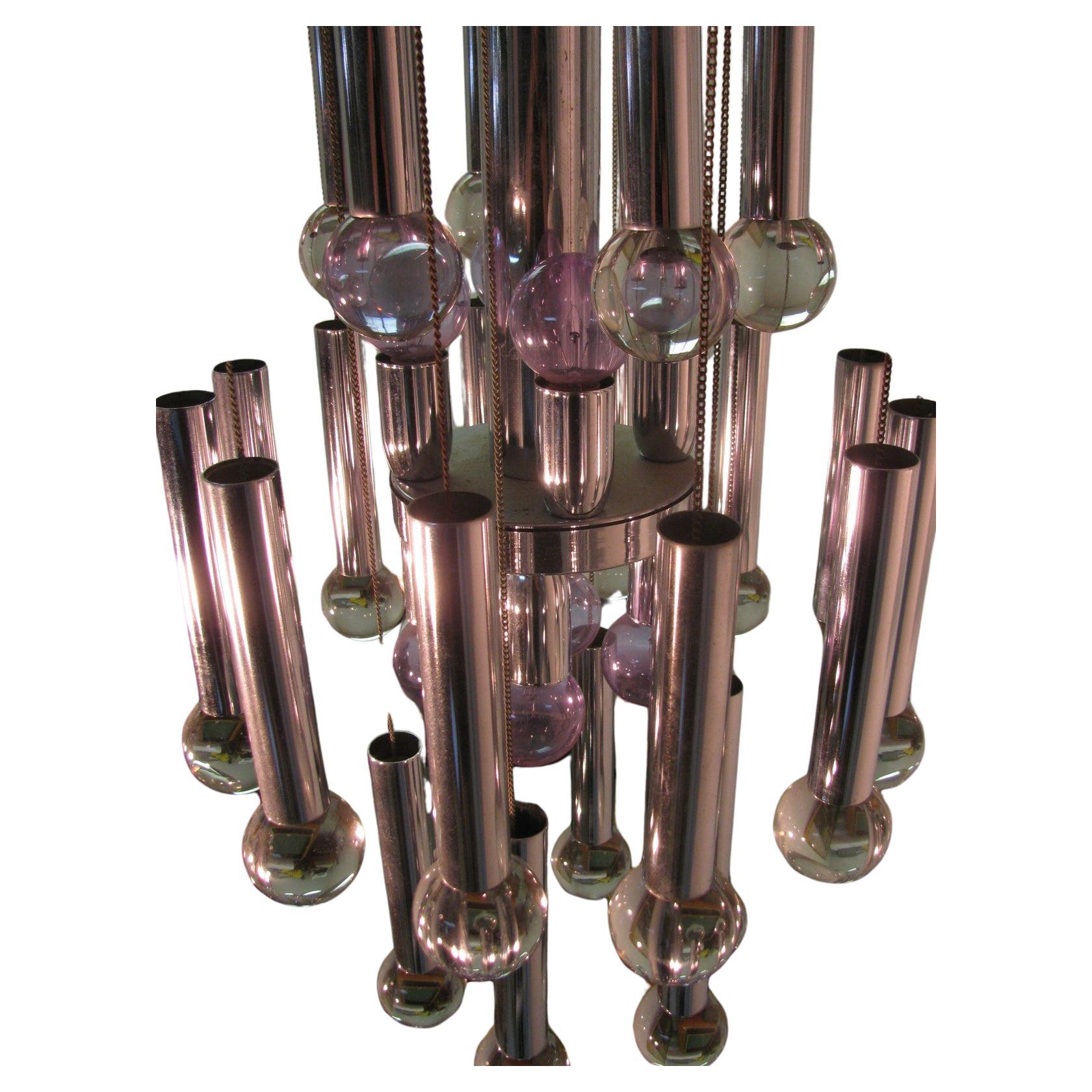 Fabulosa lámpara de araña del estudio de Gaetano Sciolari. 24 bolas de cristal macizo suspendidas por una cadena de acero inoxidable. Las bolas están coronadas por casquillos cromados en tres niveles que se iluminan con 8 bombillas. Se trata de una