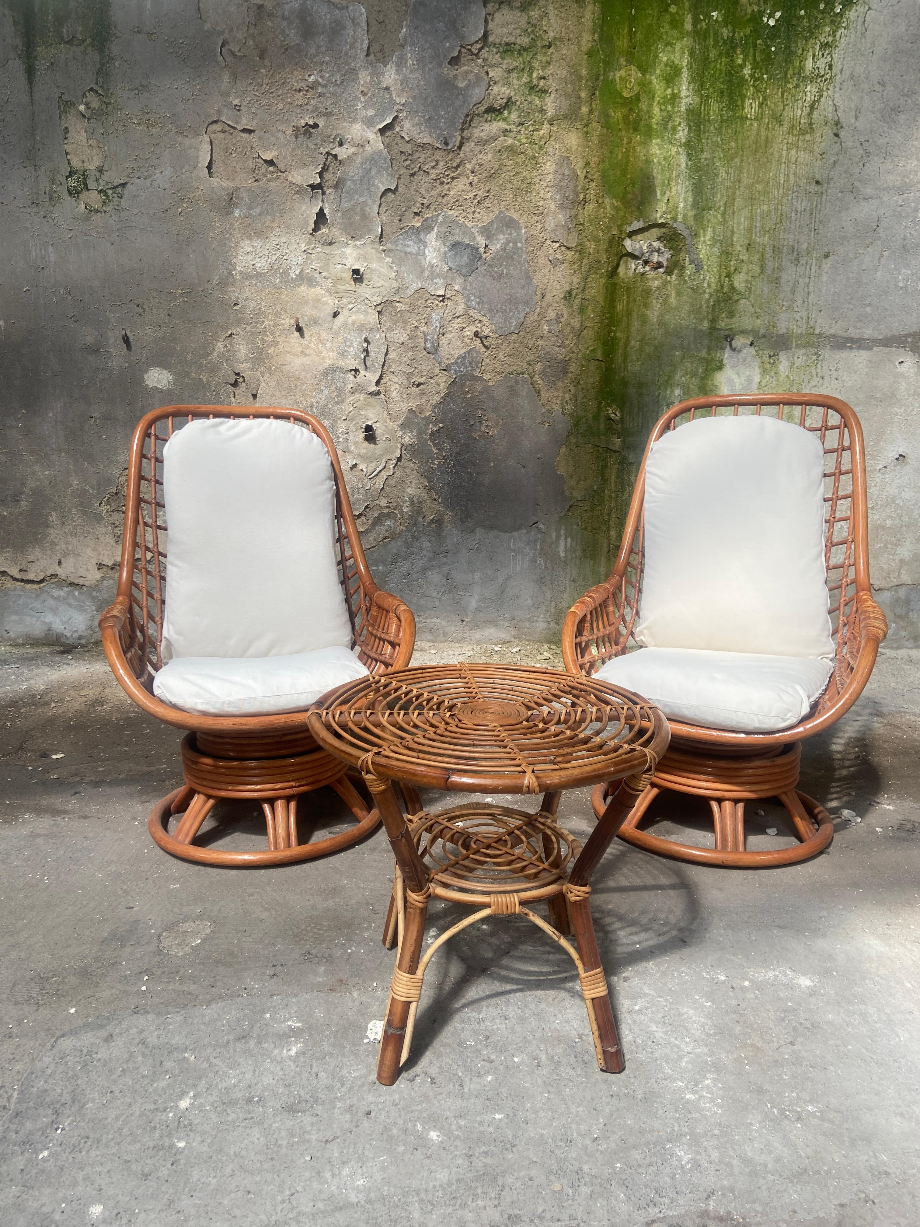 Mid-Century Modern Bamboo and Rattan living room set consists of  two comfortable armchairs and one side table.
The armchairs have their original fabric cushions.
The set is in really good vintage conditions with a beautiful patina due to age and use