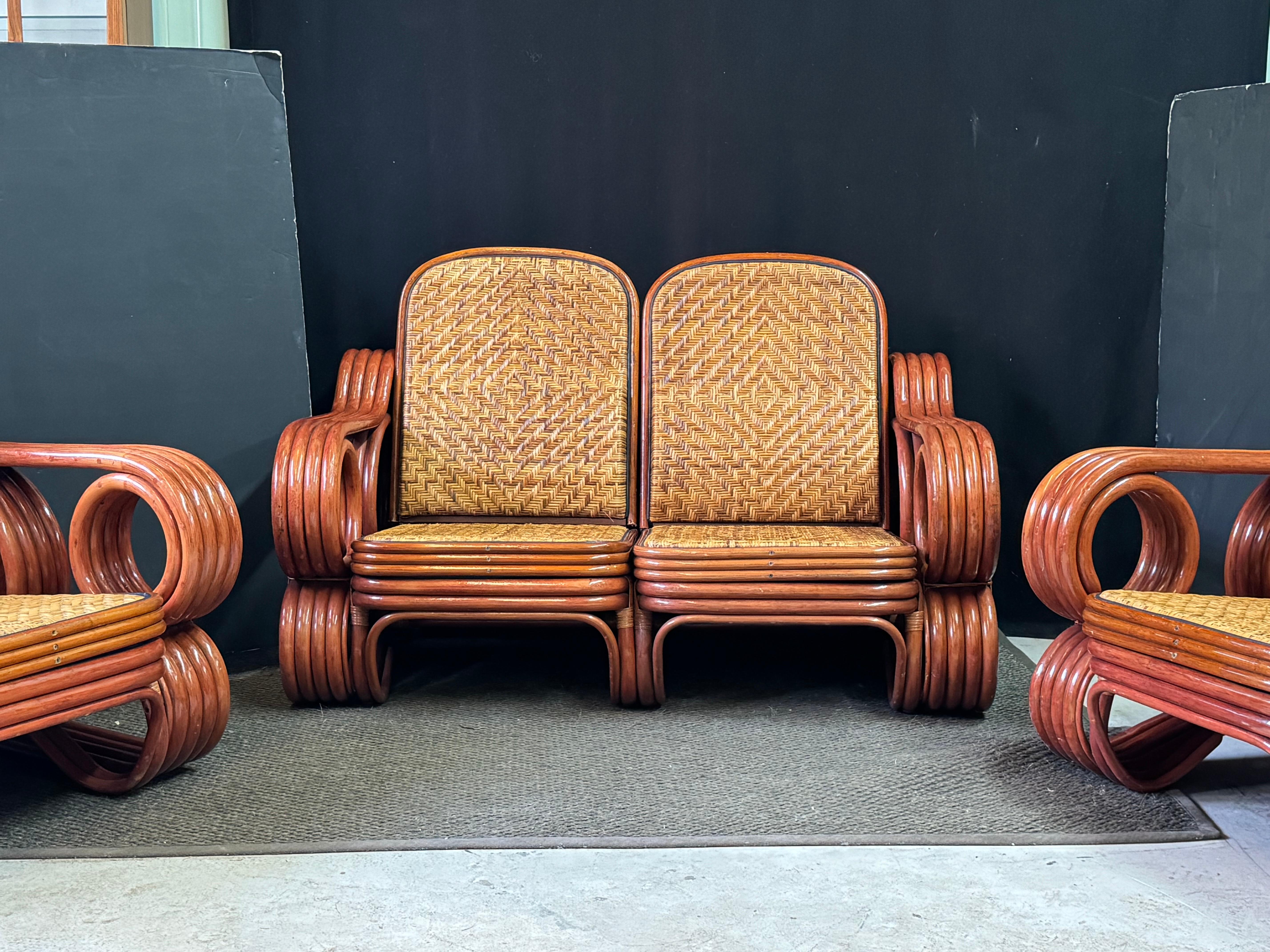Excellent quality Mid-Century Modern bamboo and rattan lounge set of Italian design. The oversized lounge chairs and matching two-seat sofa feature the traditional four strand bentwood frames but in a unique spiraling arm design that also frame a