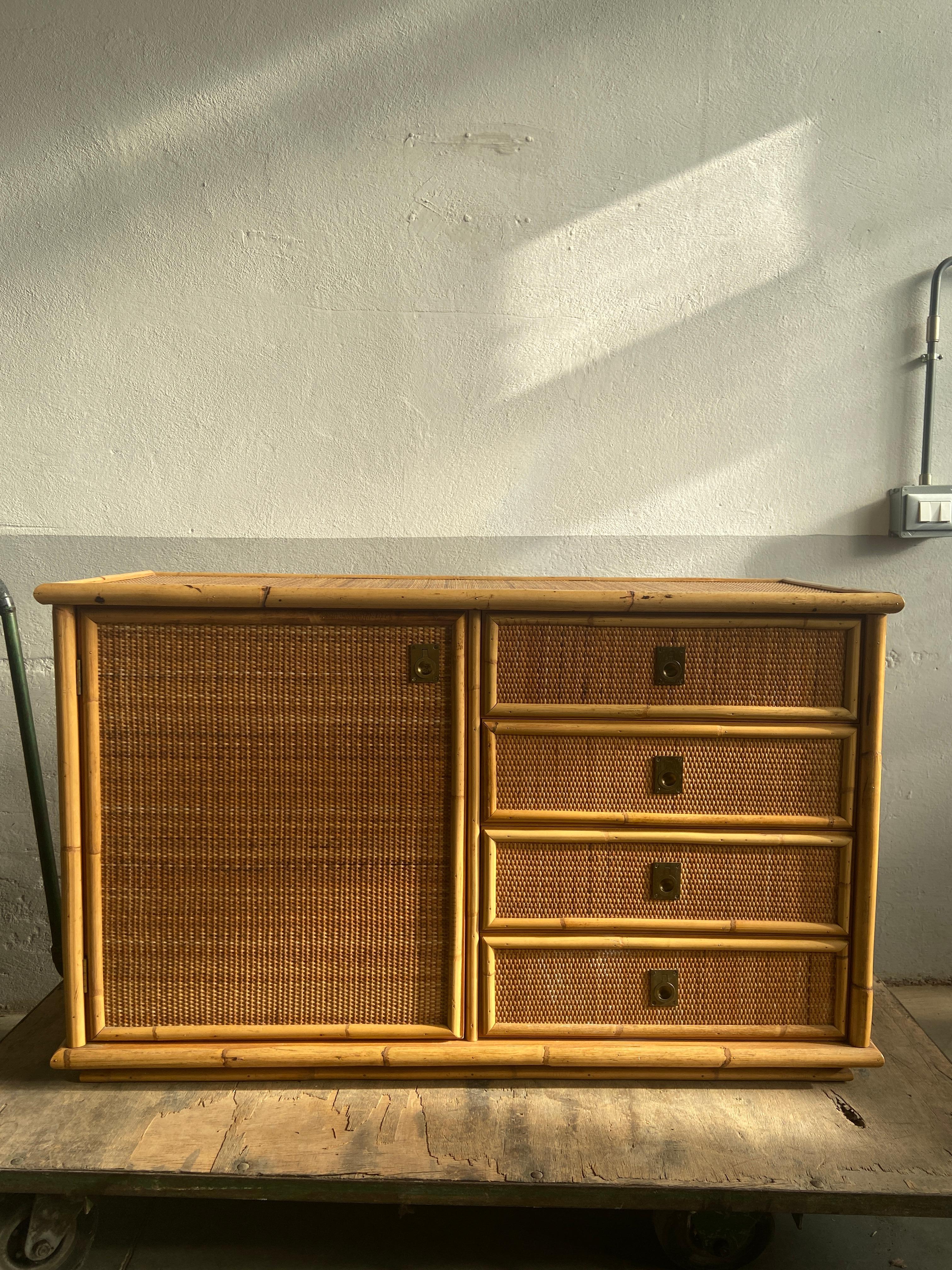 Italian Dal Vera rattan and wicker sideboard on a wooden structure, opening with a door and four drawers with solid brass handles. In excellent original vintage conditions. This piece has a wonderful patina due to age and use.